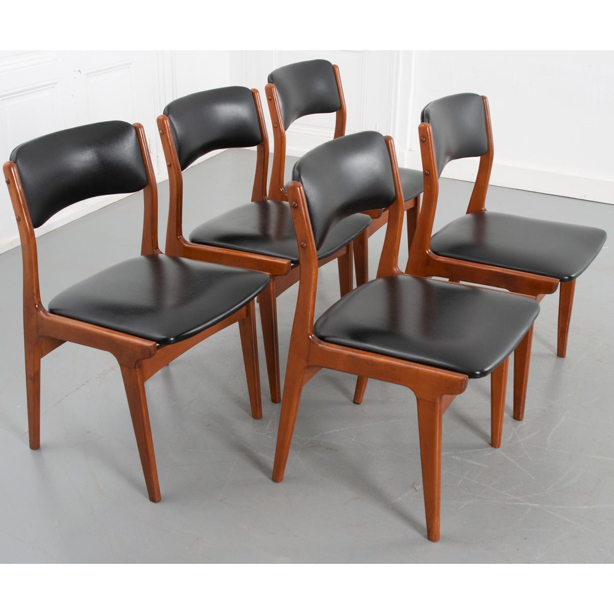 Excellent set of five Scandinavian design dining chairs. Made of teak wood with black vinyl seat cushions and backrests. Seats: 17-?”H. See detailed pictures for condition.
