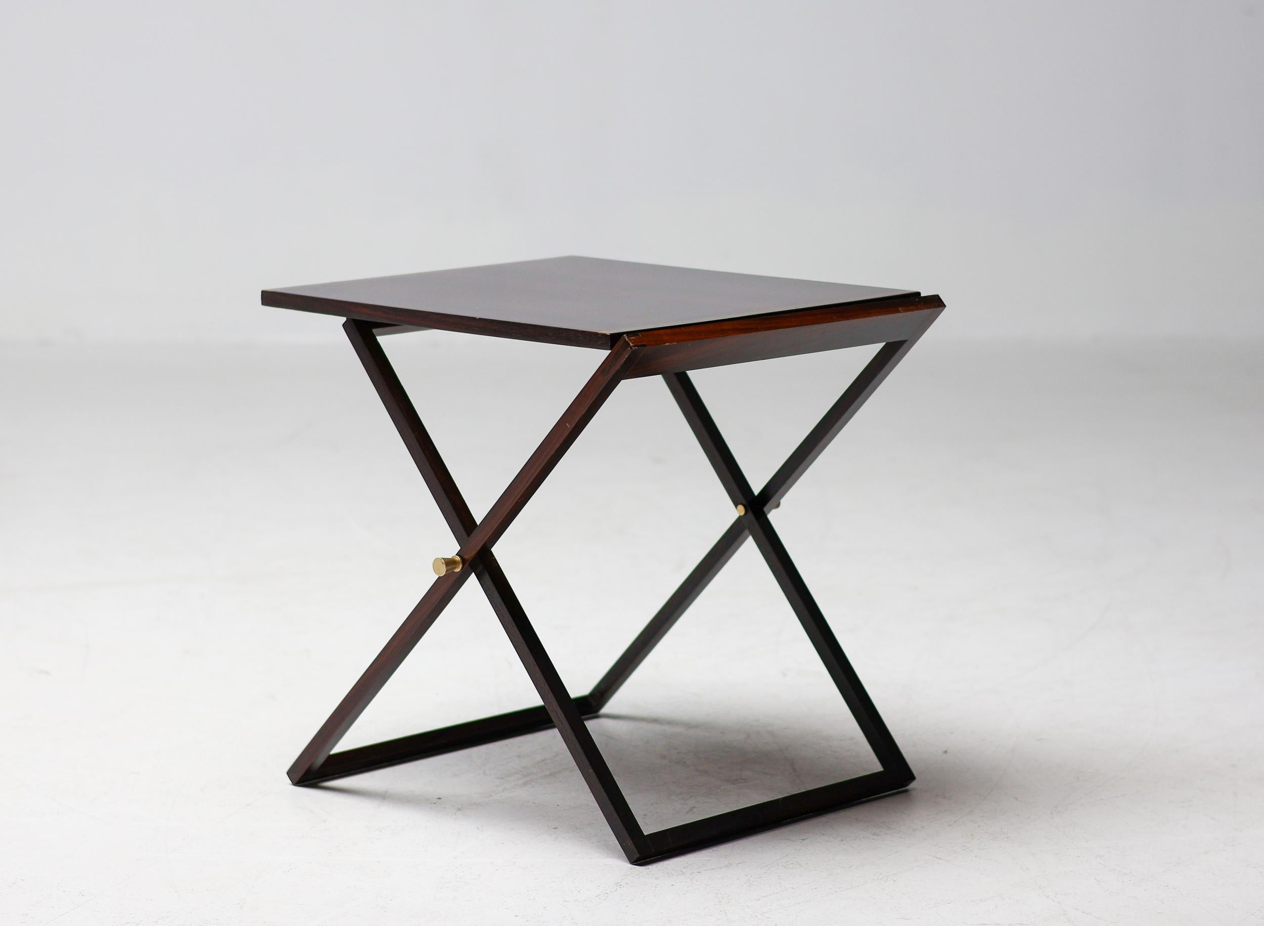 Très élégant ensemble de tables-plateaux en palissandre avec poignées et bords en laiton poli. Doté de quatre plateaux soigneusement rangés à l'intérieur du meuble, ce modèle est aussi fonctionnel qu'élégant. Les tables sont en parfait état