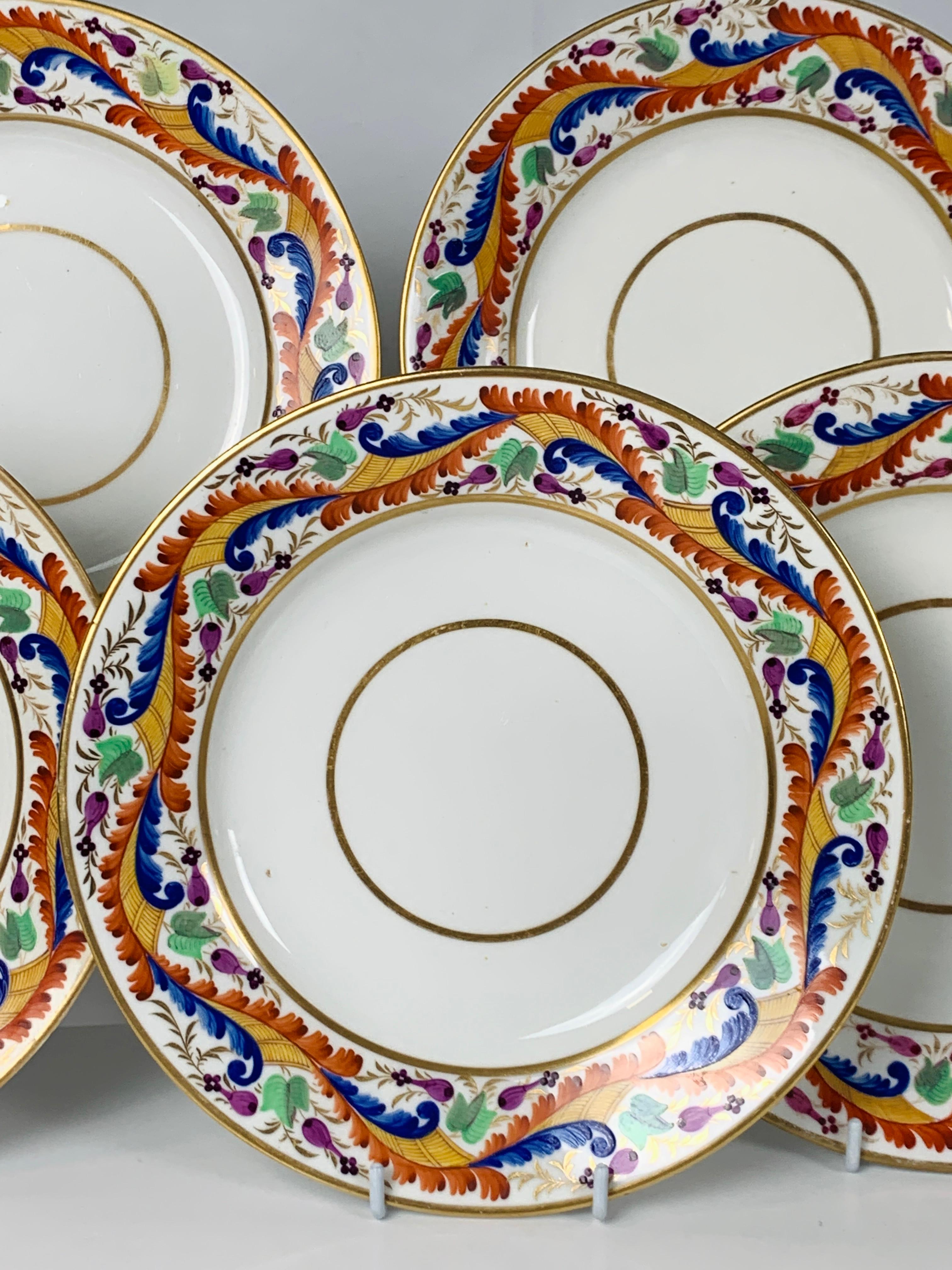 A set of five Derby dishes made in England, circa 1810. The brilliant colors of the border: red, orange, and blue combine in an exquisite vine-like pattern. The green flowers, gilded leaves, and small purple buds add to the colorful design. At the