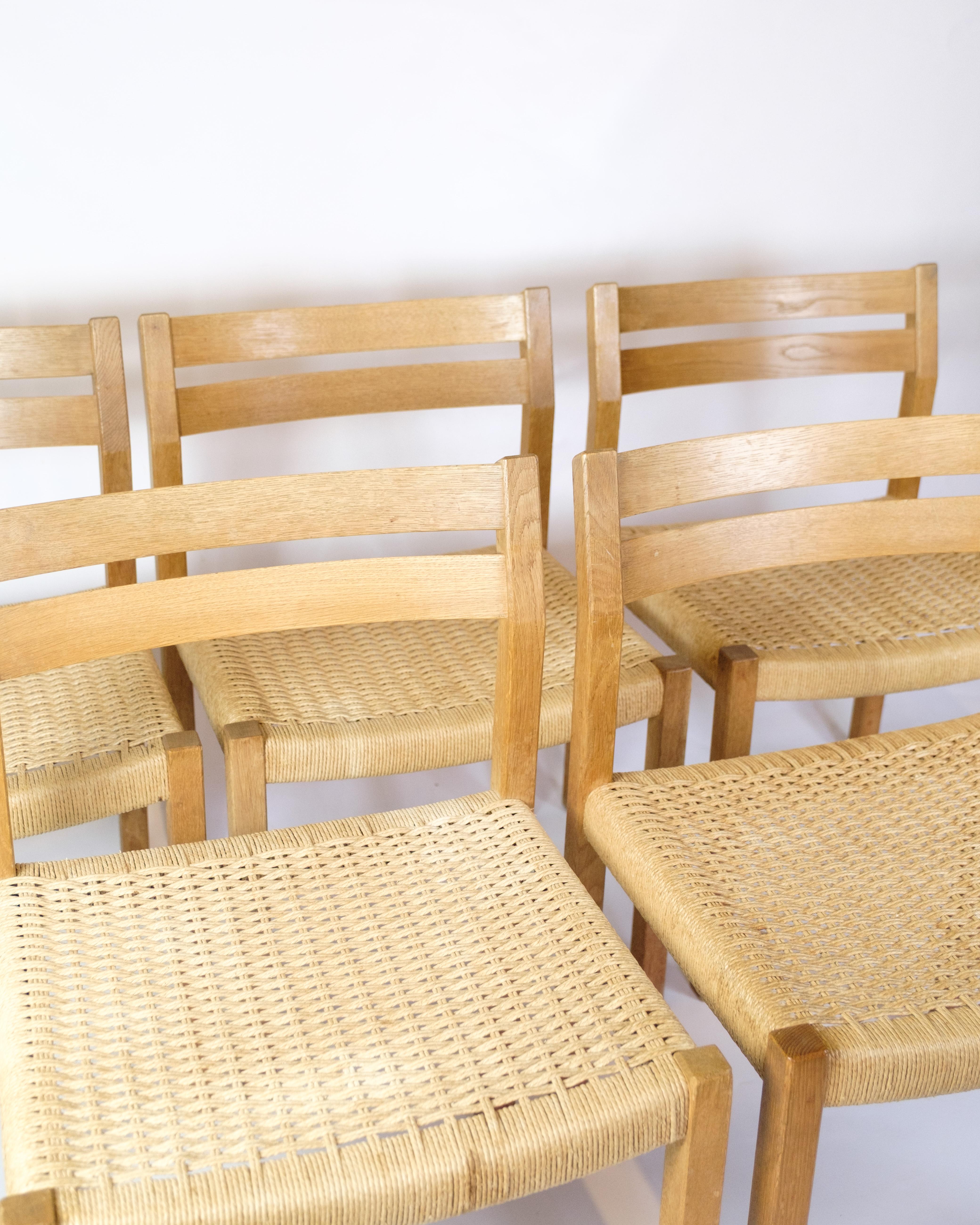 Set di cinque sedie da pranzo, modello 401, disegnate da Jørgen Henrik Møller per JL Møllers Møbelfabrik negli anni Sessanta. Realizzato in rovere massiccio con sedute piatte in vimini intrecciato a mano. Mobili danesi dal design classico con