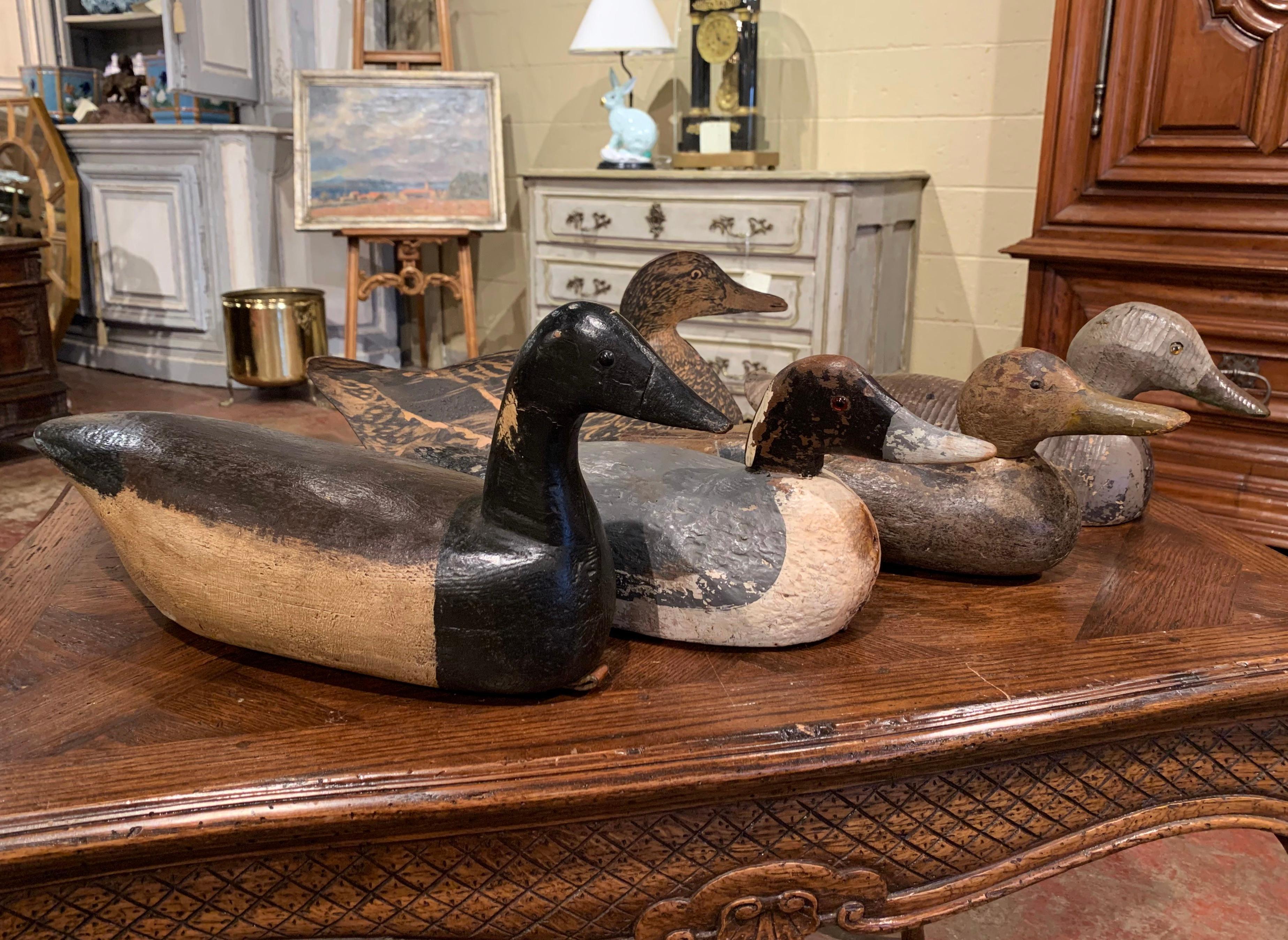 Crafted circa 1920-1940, the 5 vintage wood and fiberglass duck decoys are of varied sizes and species; each hand carved sculpture has remnants of worn paint. One bird includes a Wm. R. Johnson's folding fiberboard decoy, Seattle, Washington,