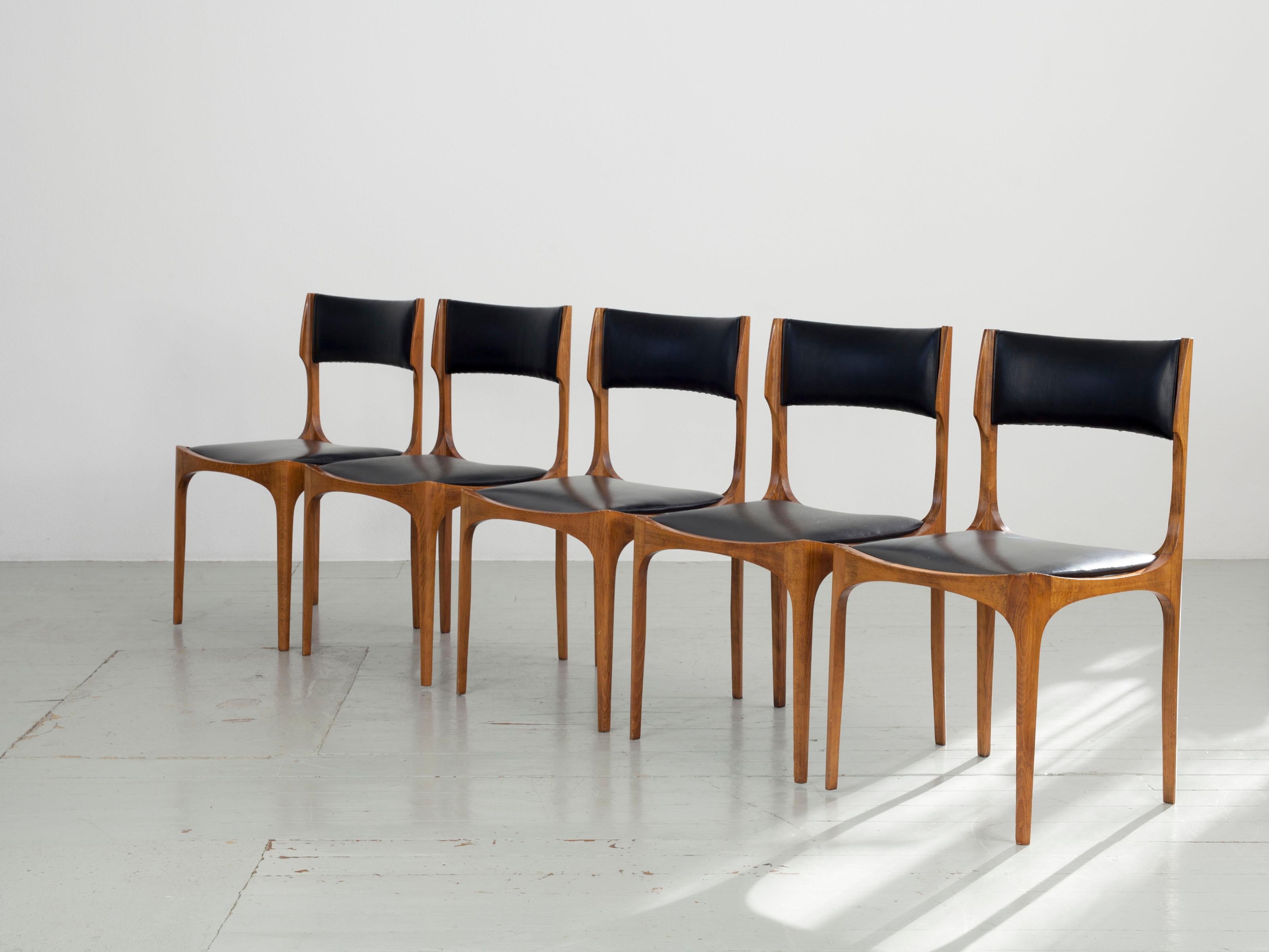Five elegant dining chairs made of beech wood, designed by Giuseppi Gibelli and manufactured by Sormani, Italy, in the 1960s. The chairs are upholstered in imitation leather. One chair has a small hole in the seat. Despite slight signs of wear, the