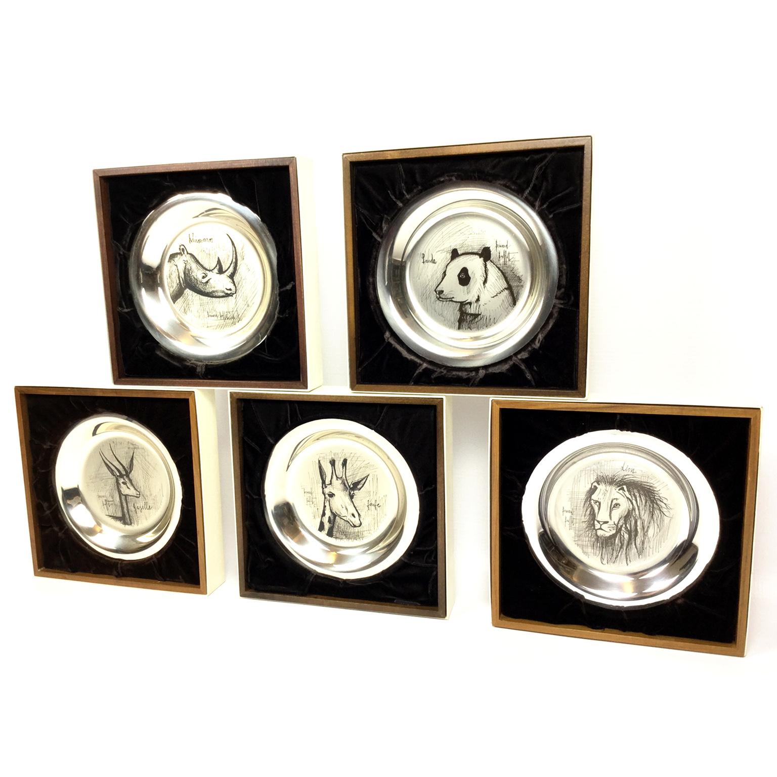 Set di piatti in argento sterling incisi e firmati da Bernard Buffet datati 1973-1978.
Gazzella, Panda, Giraffa, Leone e Rinoceronte. 
Ognuno di essi è contenuto in una vetrina in legno con finitura in velluto marrone.
Tutti con numeri in