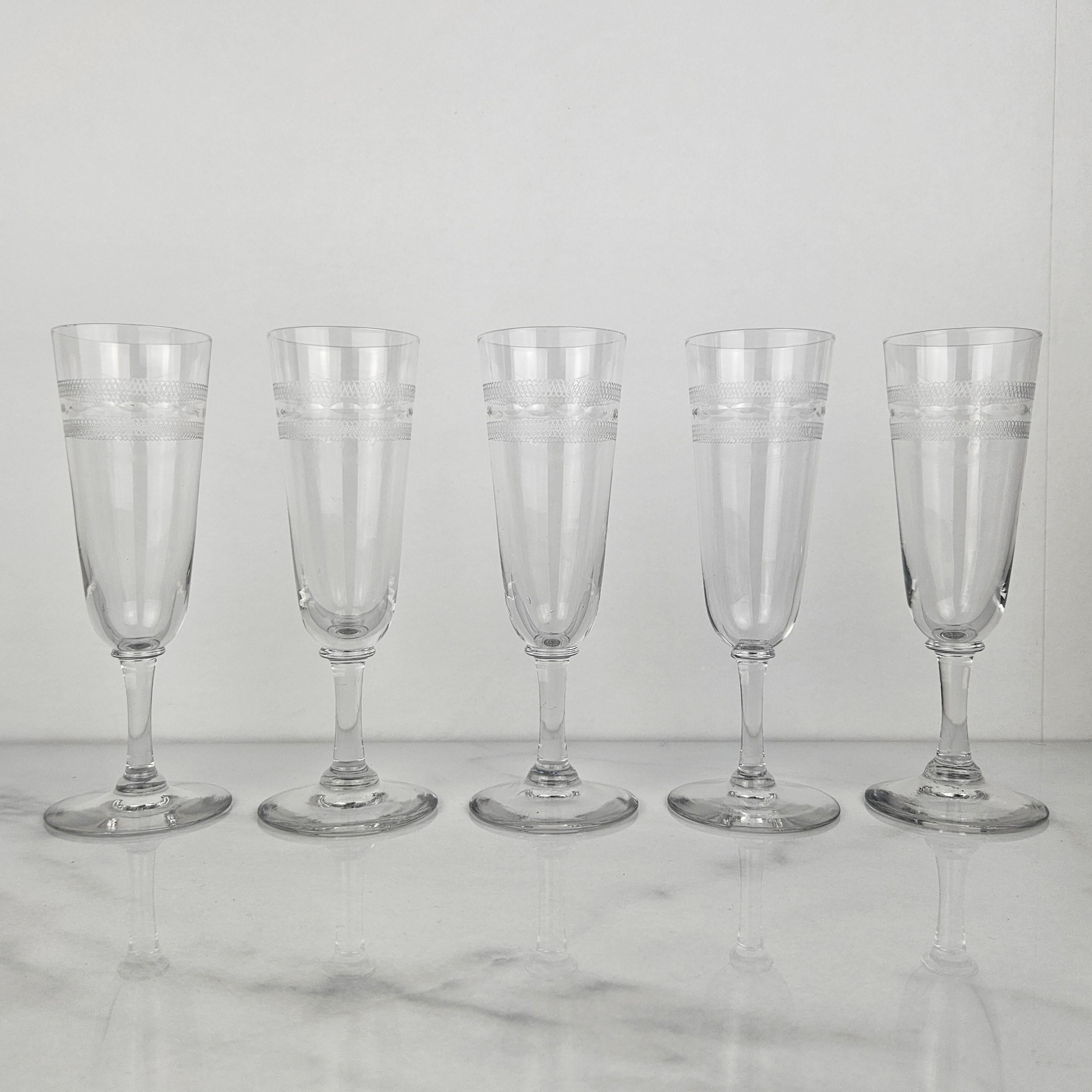 Un bel ensemble de cinq flûtes à champagne françaises en verre, fabriquées à la main vers 1890.  

Ces verres anciens sont soufflés à la bouche et taillés à facettes. 

Remarquez les très beaux détails et le design élégant.
Méticuleusement