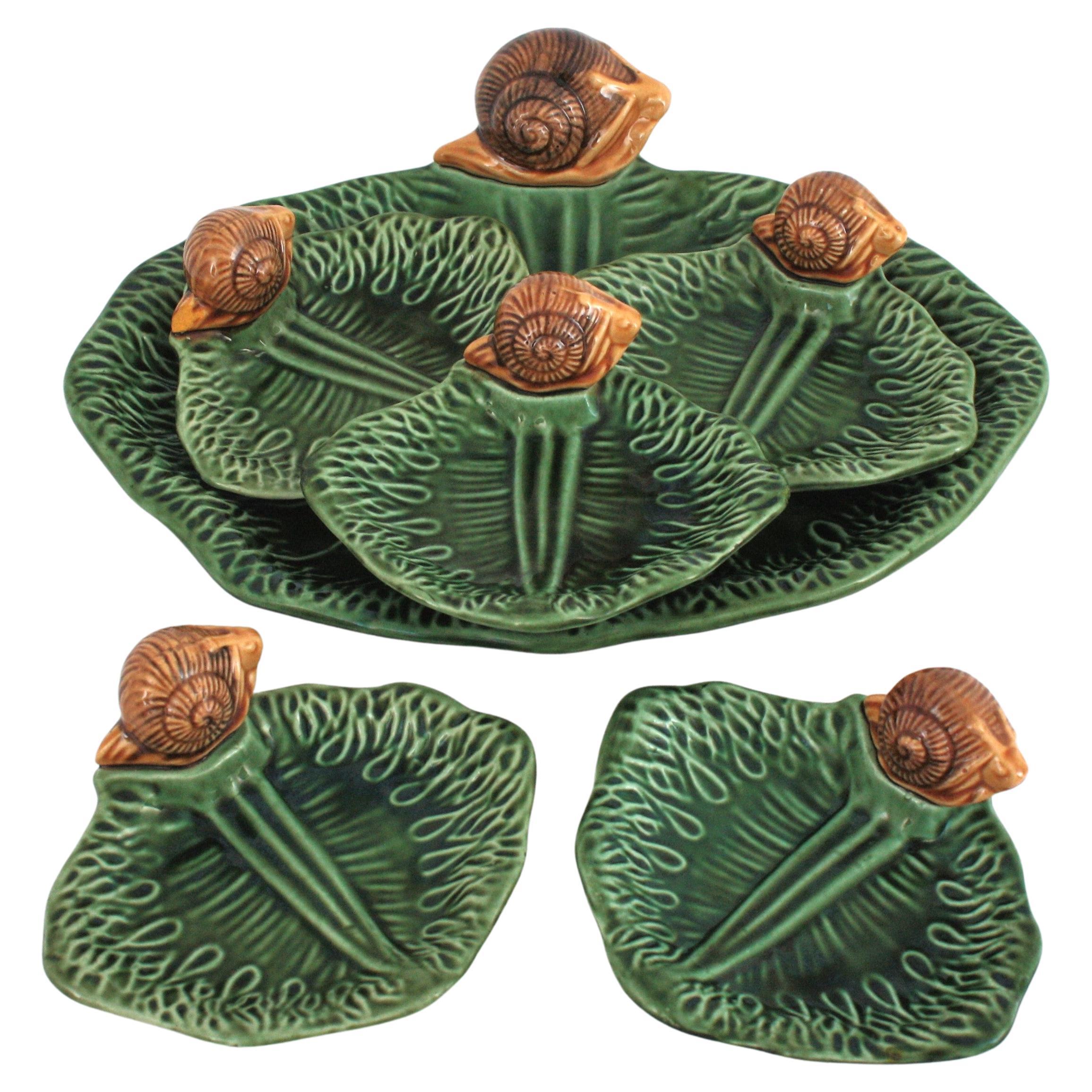 Service de table Escargots, Majolique, Céramique émaillée, France, années 1960.
Ensemble de service pour cocktail d'escargots unique en son genre : composé de 5 plats à escargots en céramique Majolica et d'un grand plat de service.
Les assiettes et
