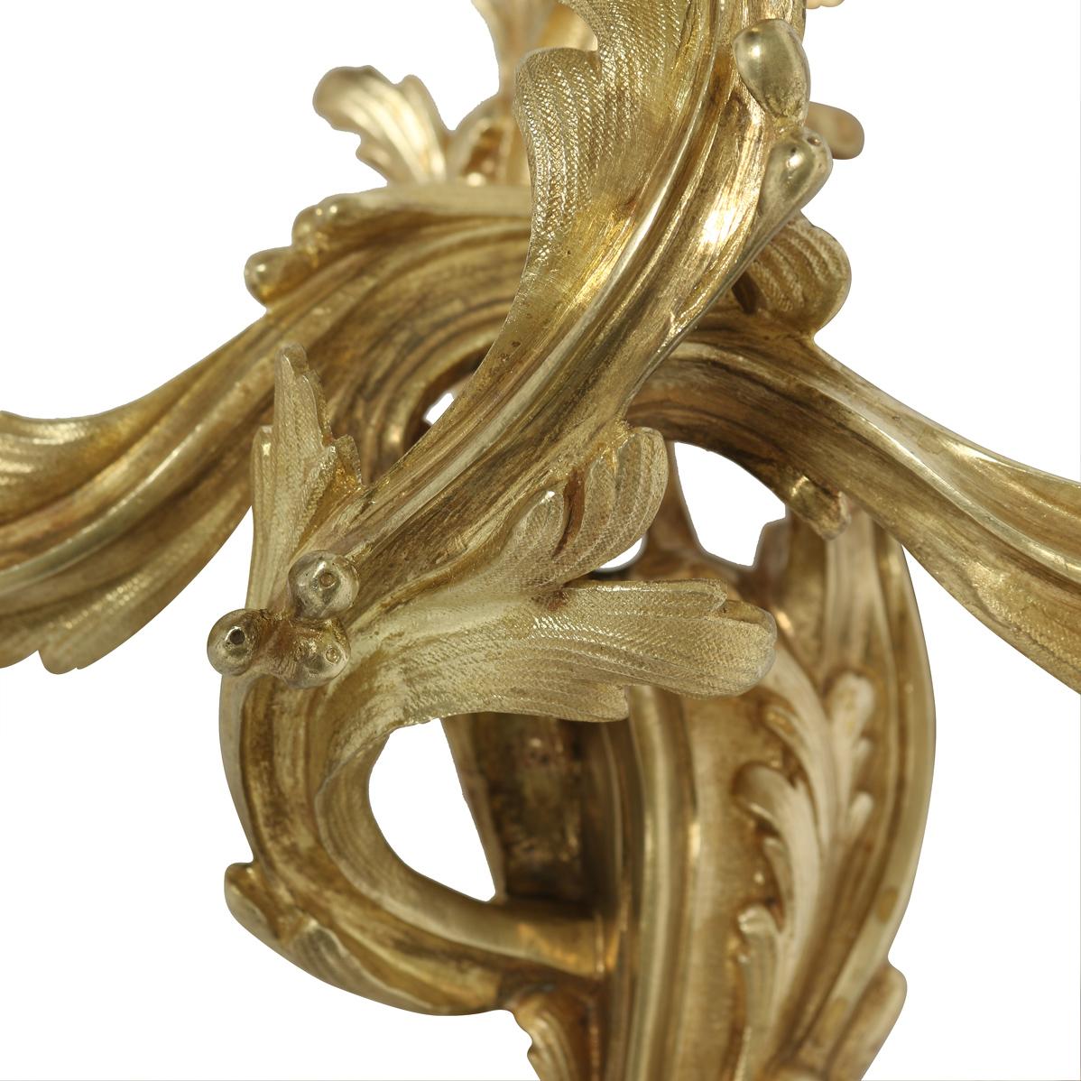 Set of five gilt bronze, three arm sconces in Louis XV style. Elegant addition to a space.