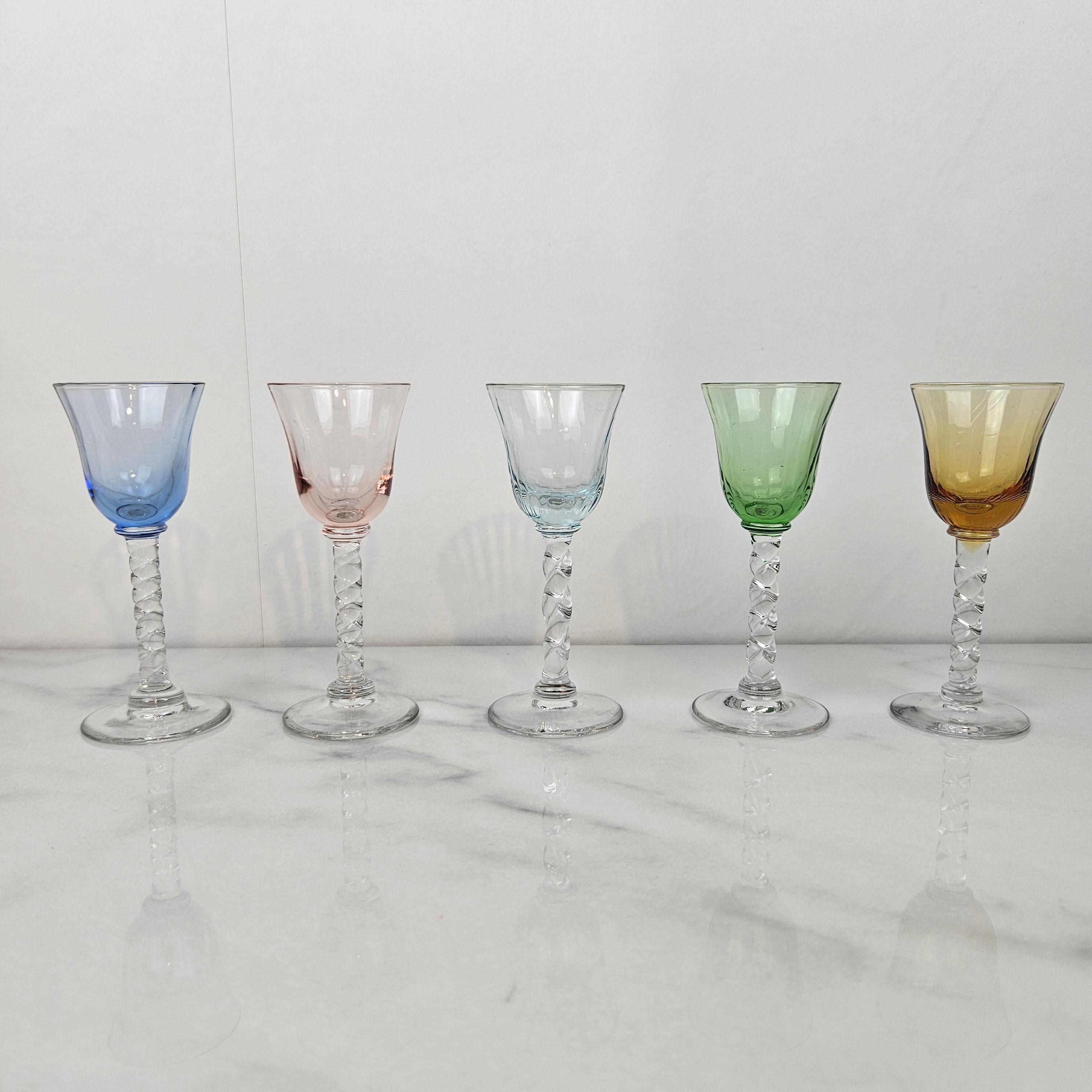 An exquisite set of five hand-blown cordial glasses dating from around 1930. Each glass features a beautifully twisted stem and a lightly ribbed bowl in soft, translucent tones — smoke grey, green, blush pink, sky blue, pale aqua, and amber.

The