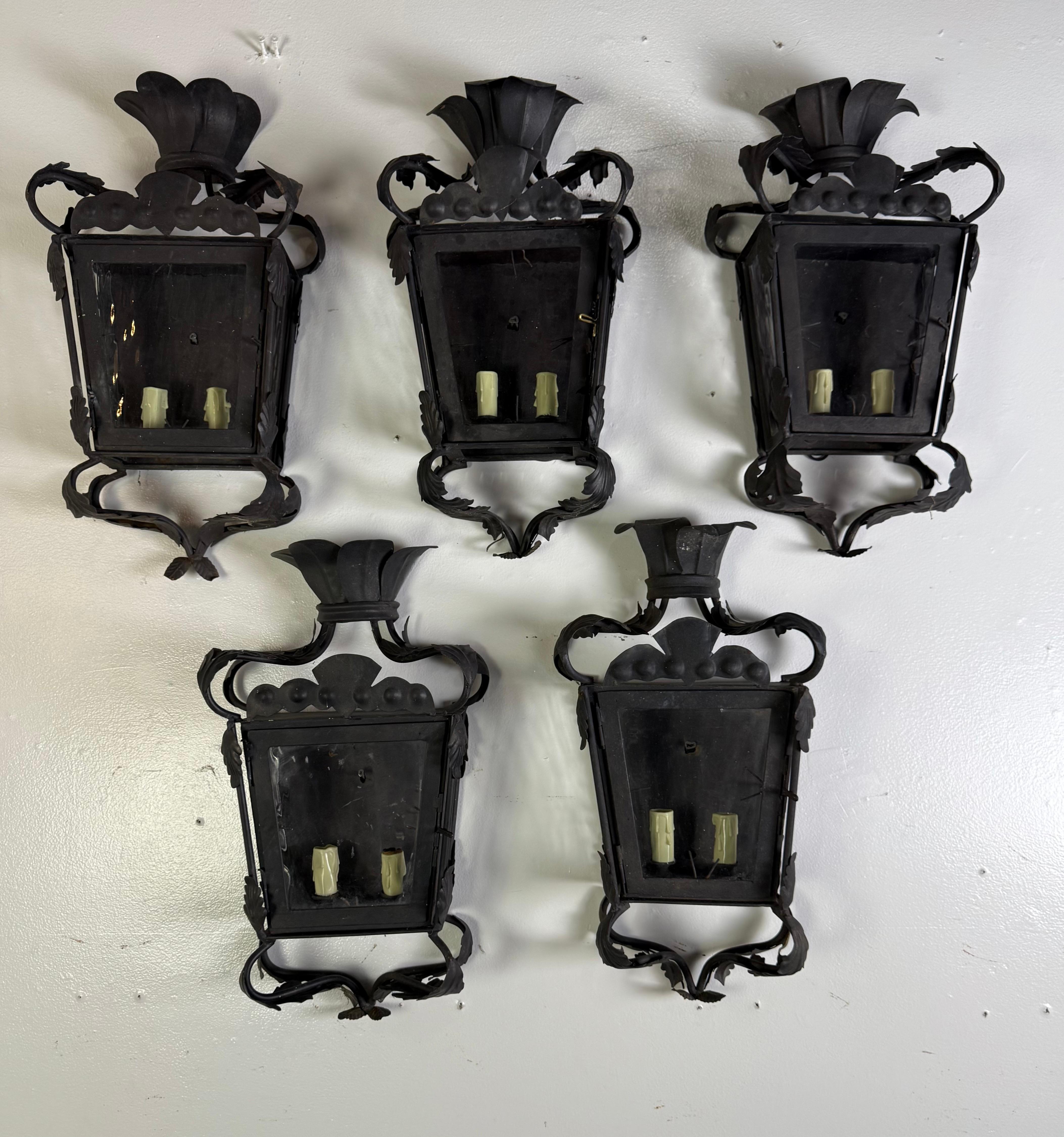 Conjunto de cinco faroles de pared de hierro forjado español forjado a mano con paneles de cristal originales
Principios del siglo XX  Recuperado de una finca histórica de Hancock Park  Cableado para instalación

Raro y bellamente patinado conjunto
