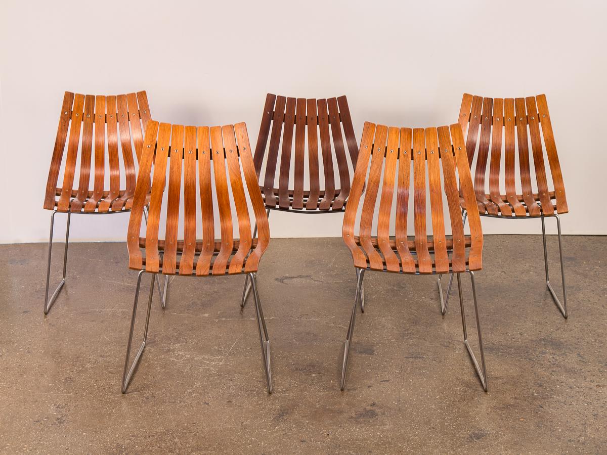 Set of five Hans Brattrud dining chairs with the low-back design. Iconic Norwegian midcentury design. Striking slatted dining chairs constructed of the original laminated rosewood with chrome-plated steel bases. This ergonomic form melds to it’s