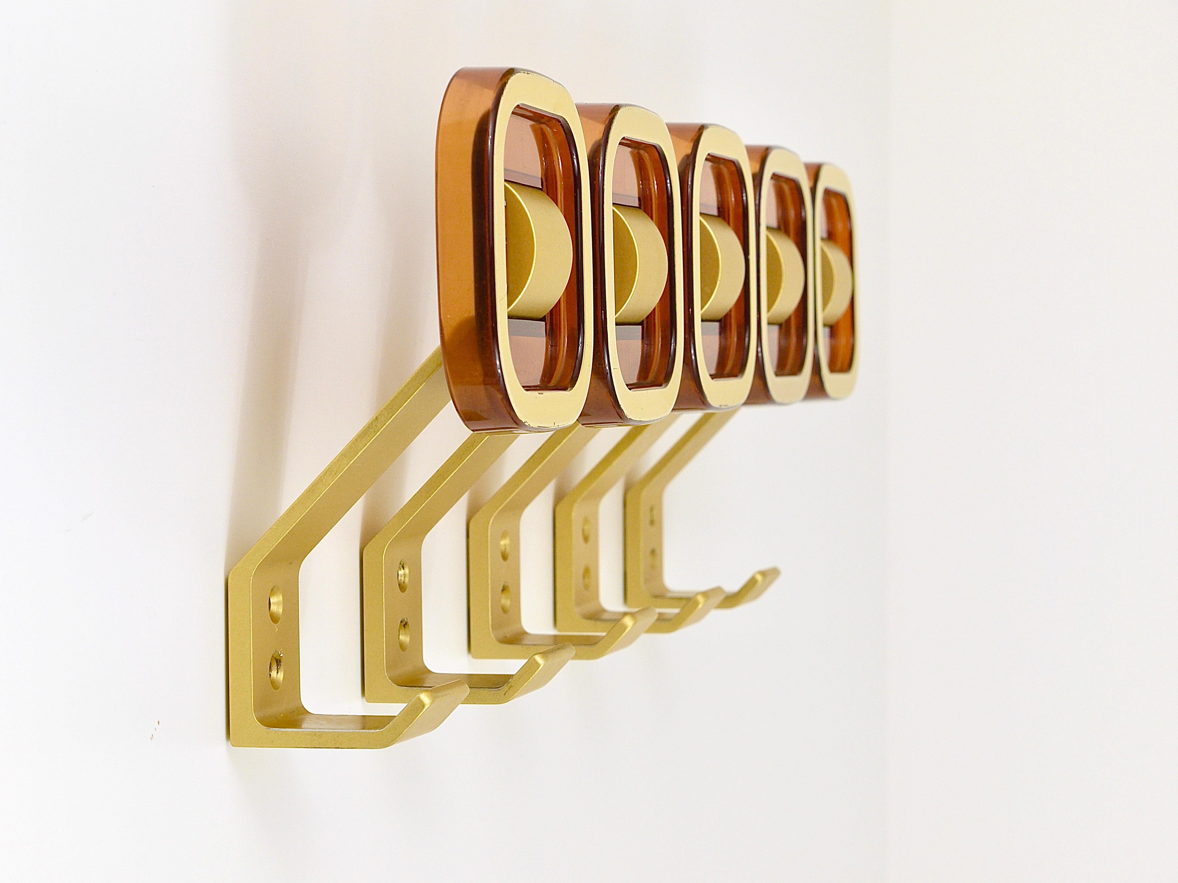 A set of five beautiful Midcentury Hollywood Regency style wall hooks from the 1970s. Made of golden anodized aluminum and smoked brown plastic with a golden rim. In very good condition.
