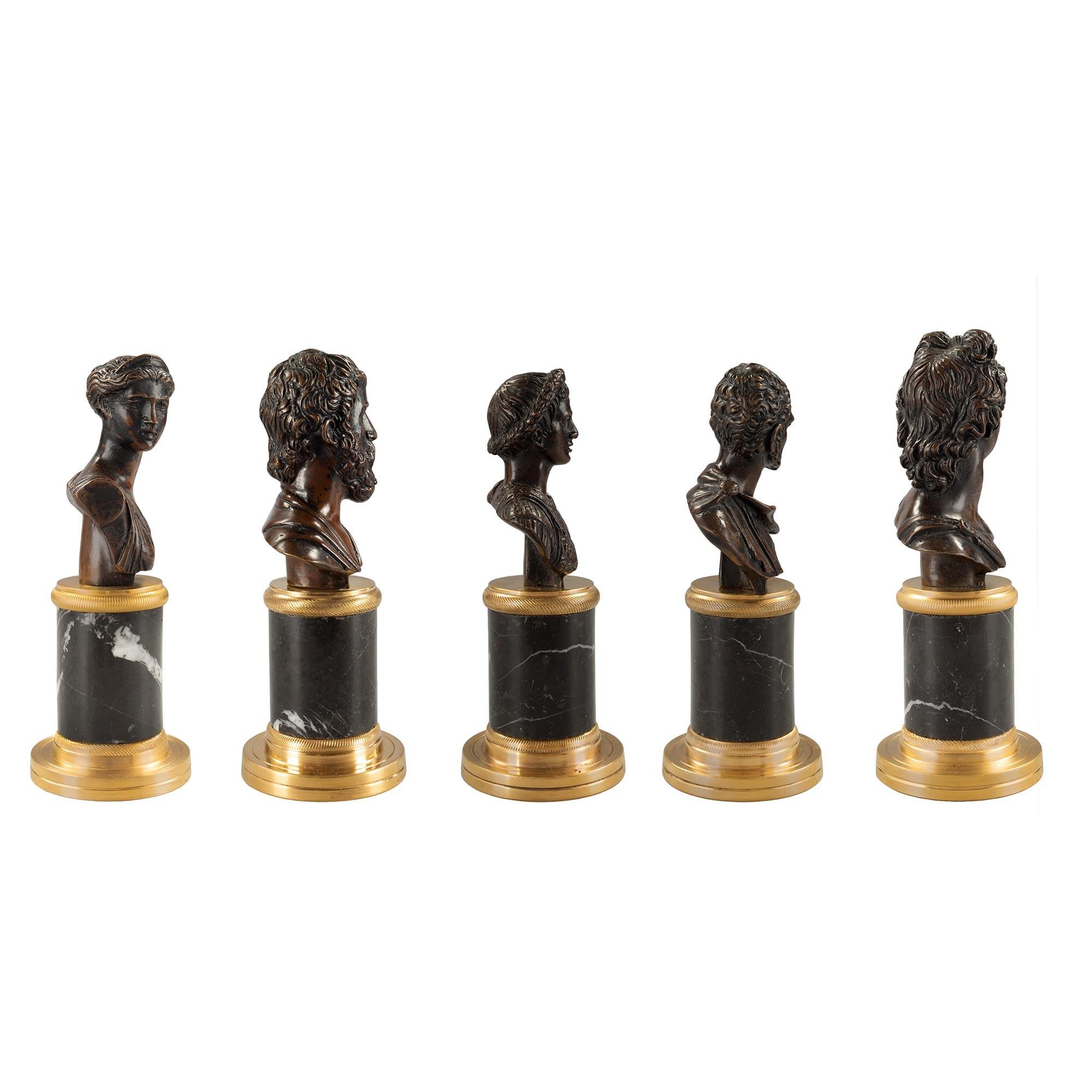 A charming set of five Italian 19th Century Neo-Classical st. patinated bronze and ormolu statuettes. Each superb bronze is raised by a circular ormolu base below the Nero Antico marble column with ormolu top cap. Above each column sits the five