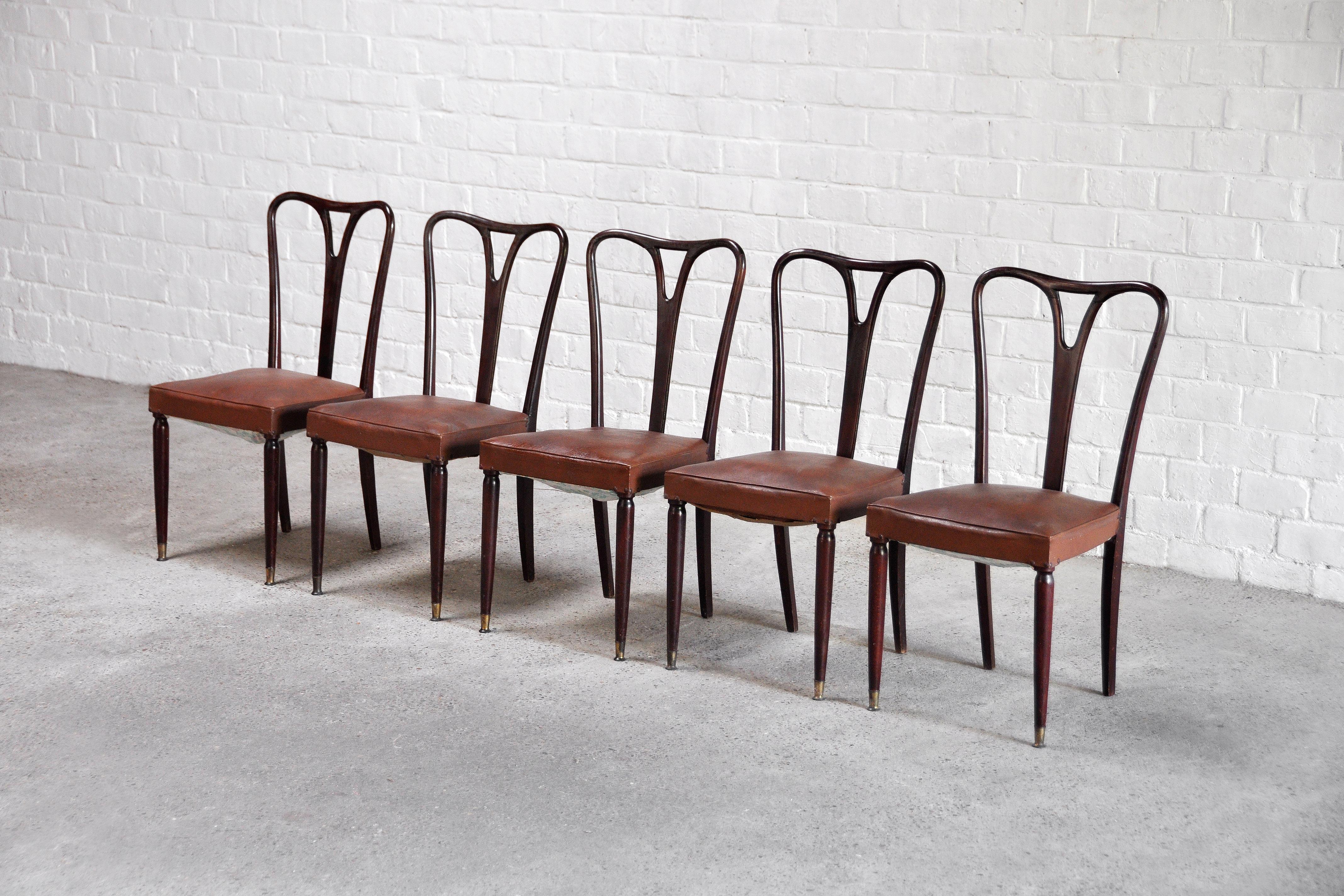 A set of 5 elegant Italian dining chairs attributed to Carlo Enrico Rava, 1950's. These chairs feature a sculptural wooden frame accented with brass tips and retain their original padded leather seats. 

In original condition, wear consistent with