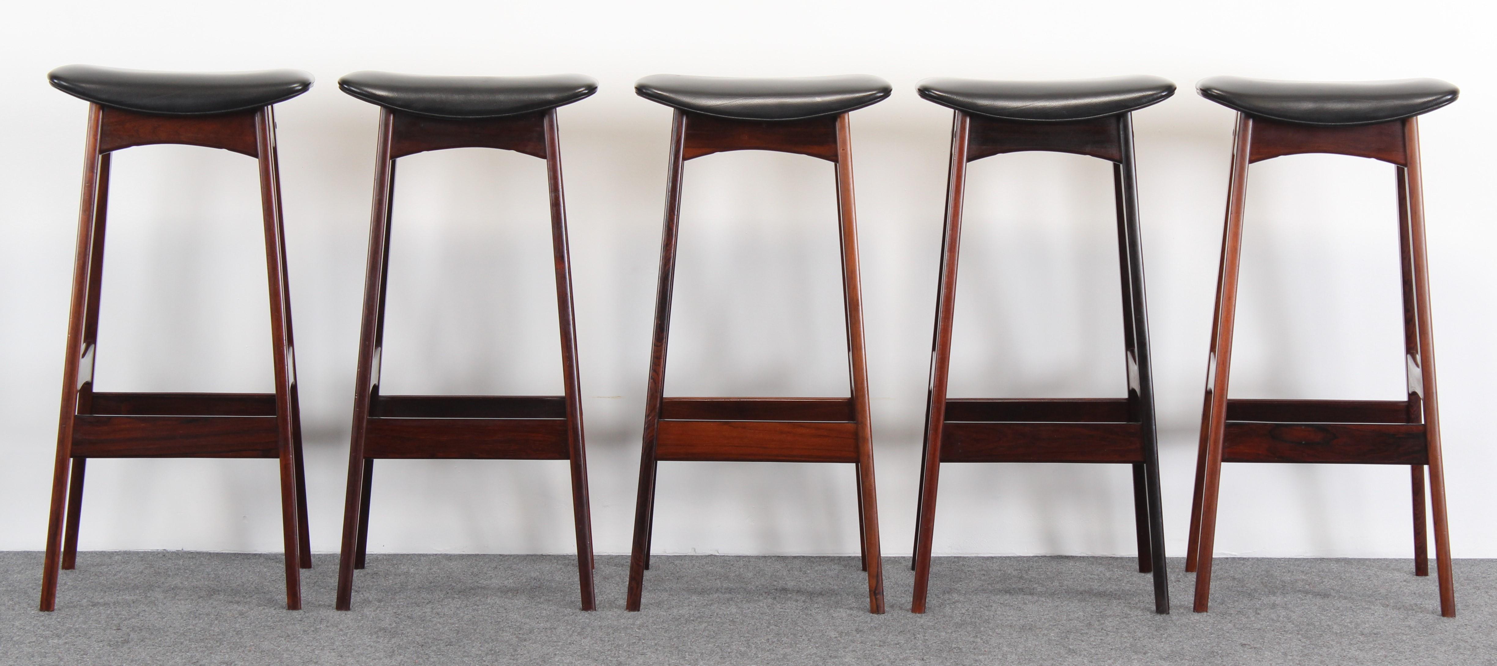 A fabulous set of five rosewood bar stools designed by Johannes Andersen manufactured by Brdr. Andersen Vejen Denmark, 1960s. These stools have the original faux leather upholstery. Very good condition with age appropriate wear.