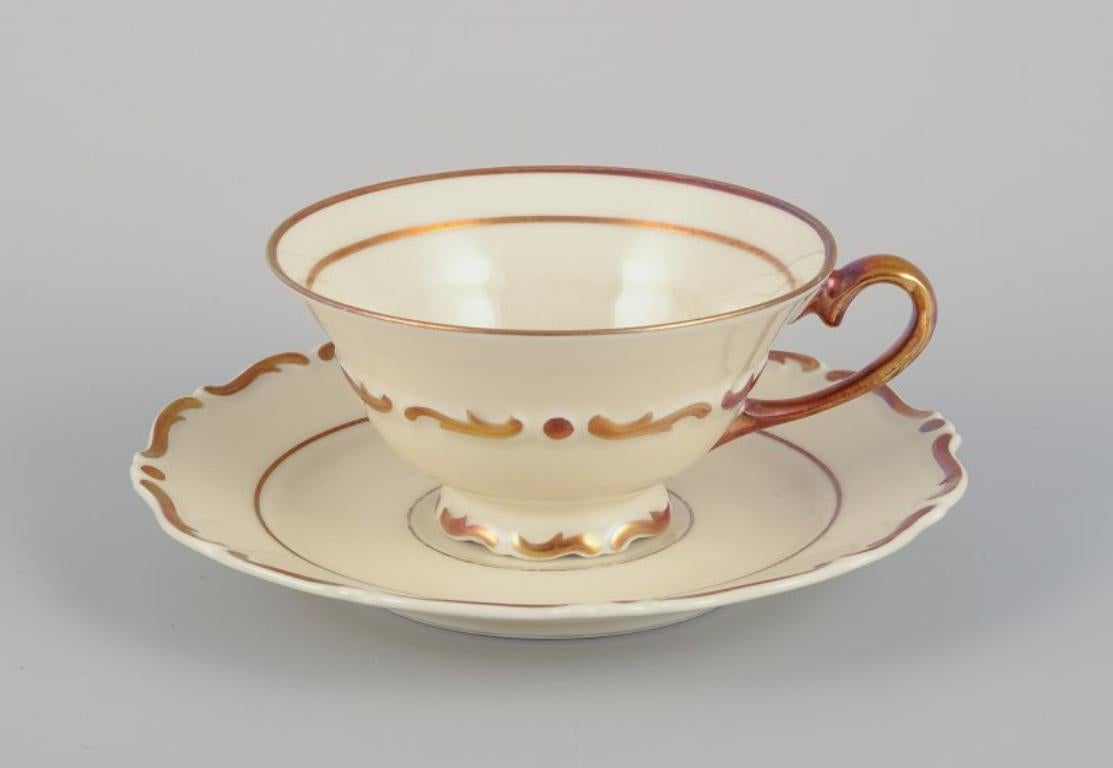 A set of five KP, Karlskrona tea cups with saucers and a creamer in cream-colored porcaelain with gold decoration.
Classic style.
1930s/1940s.
Marked.
In perfect condition.
Cup: D 9.6 cm. without the handle x H 5.0 cm.
Saucer: D 14.5 cm.
Creamer: L