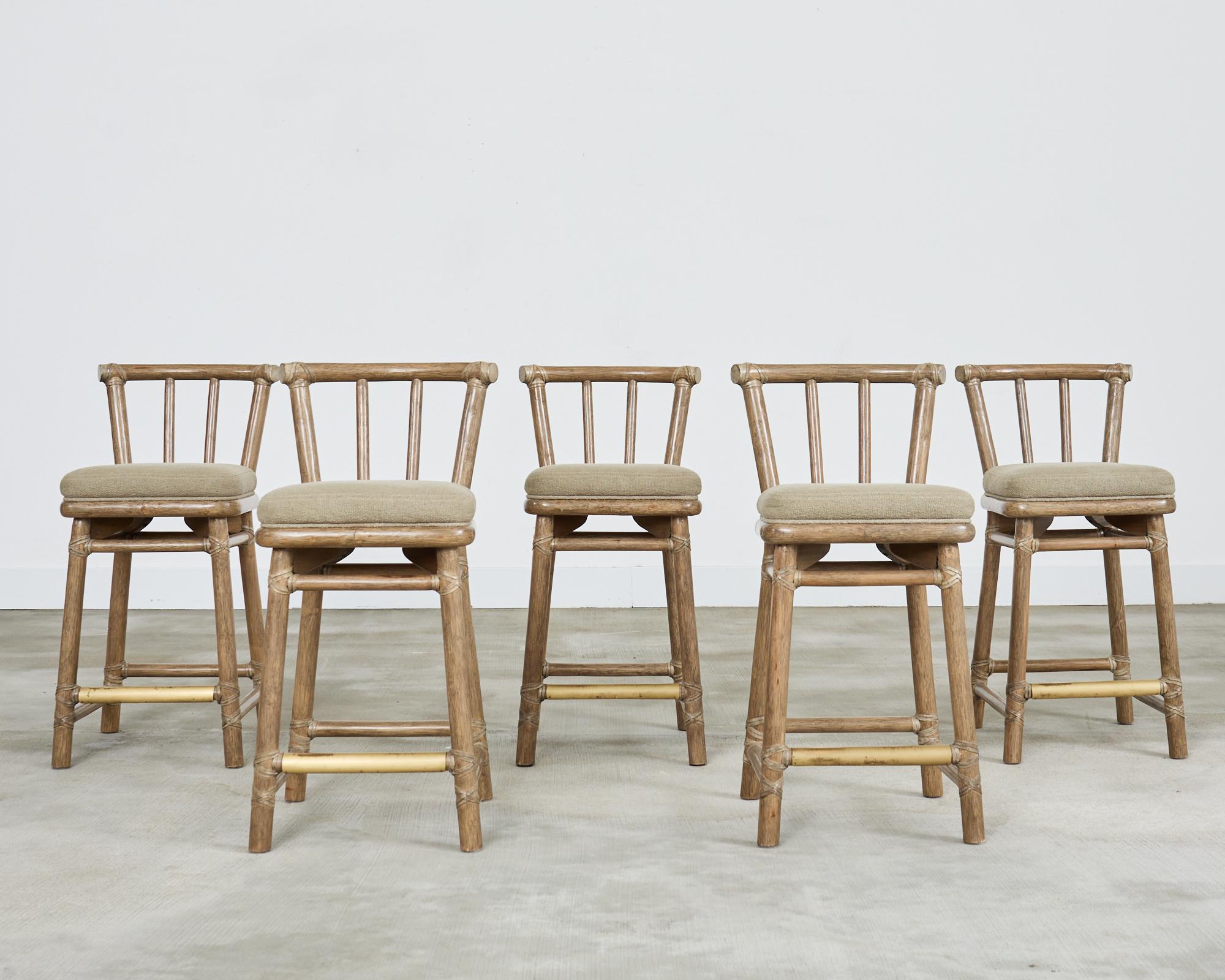 Exceptional set of five McGuire matching counter height bar stools crafted from rattan and oak. The stools feature a thick pole rattan frame lashed together with leather rawhide laces on the exposed joints. The frames are finished in a bespoke