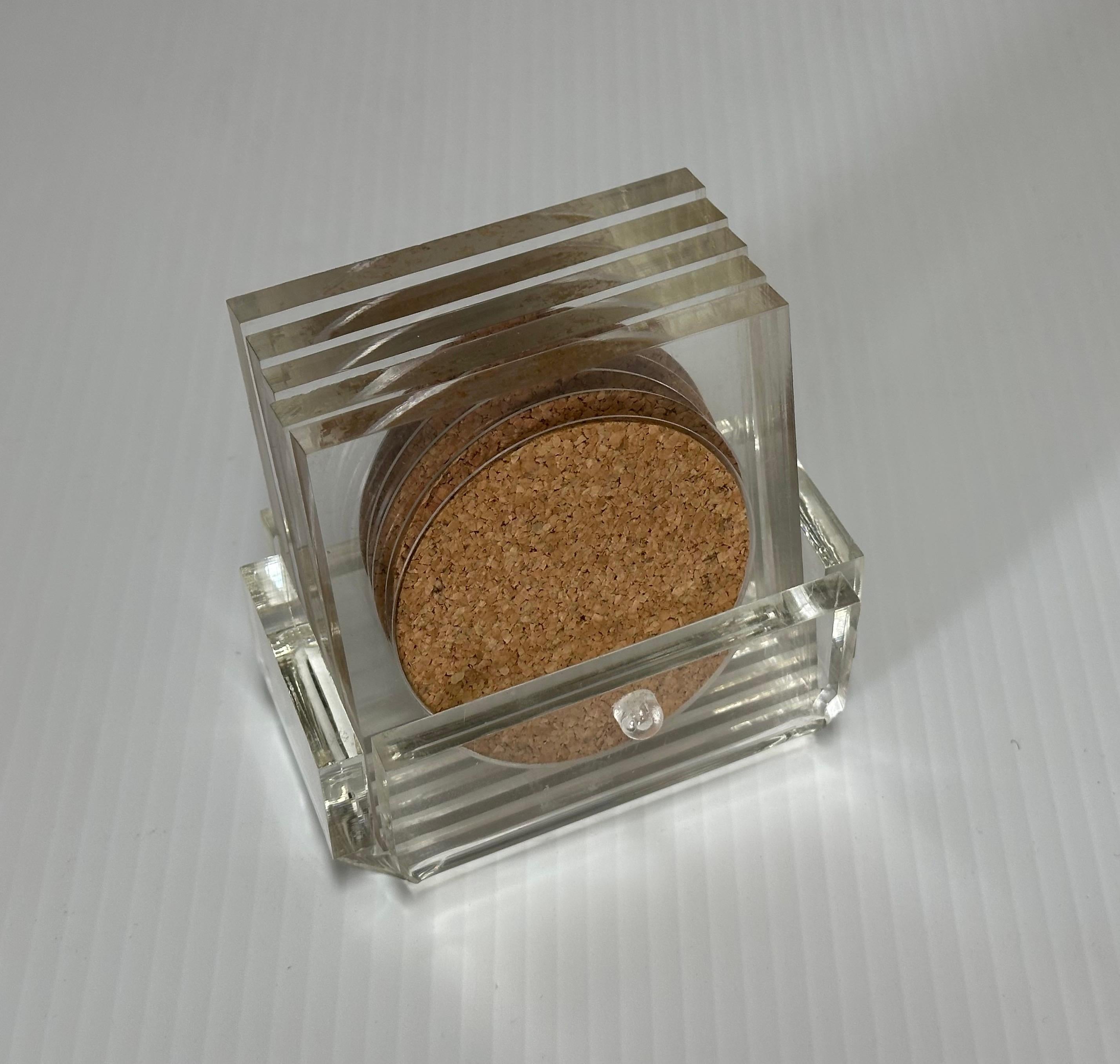 Set of Five MCM Clear Lucite Coasters with Cork Inserts and Lucite Coaster Holder. A nice set of five clear Lucite drink coasters and holder, circa 1970s. The coasters have a cork lining and are in good vintage condition. The set with coasters in