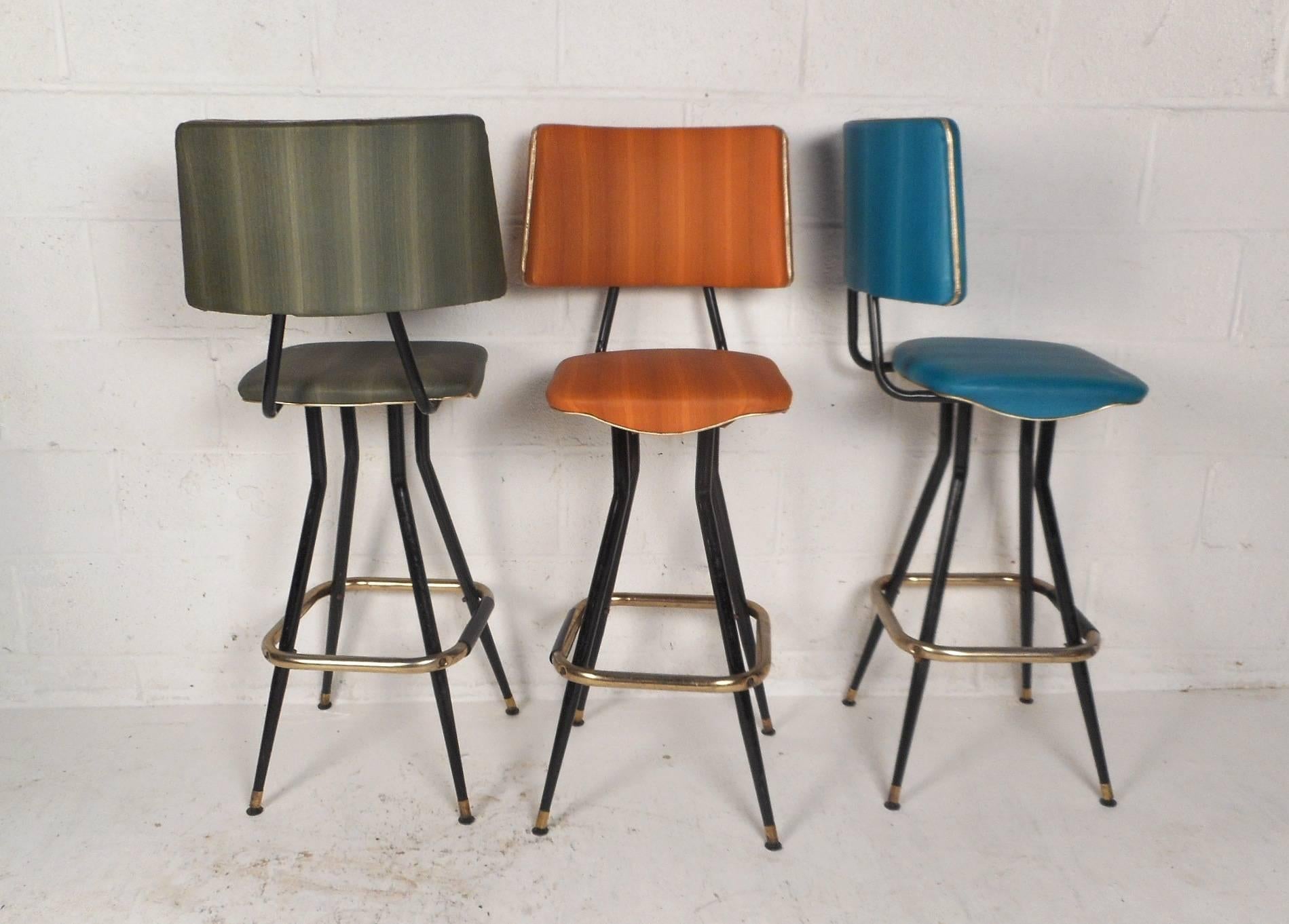 This stylish vintage modern set of five bar stools feature different colored upholstery on each one. Thick padded back rests and seats with perfect contours ensure maximum comfort within any seating arrangement. Sturdy bent rod metal frames with a