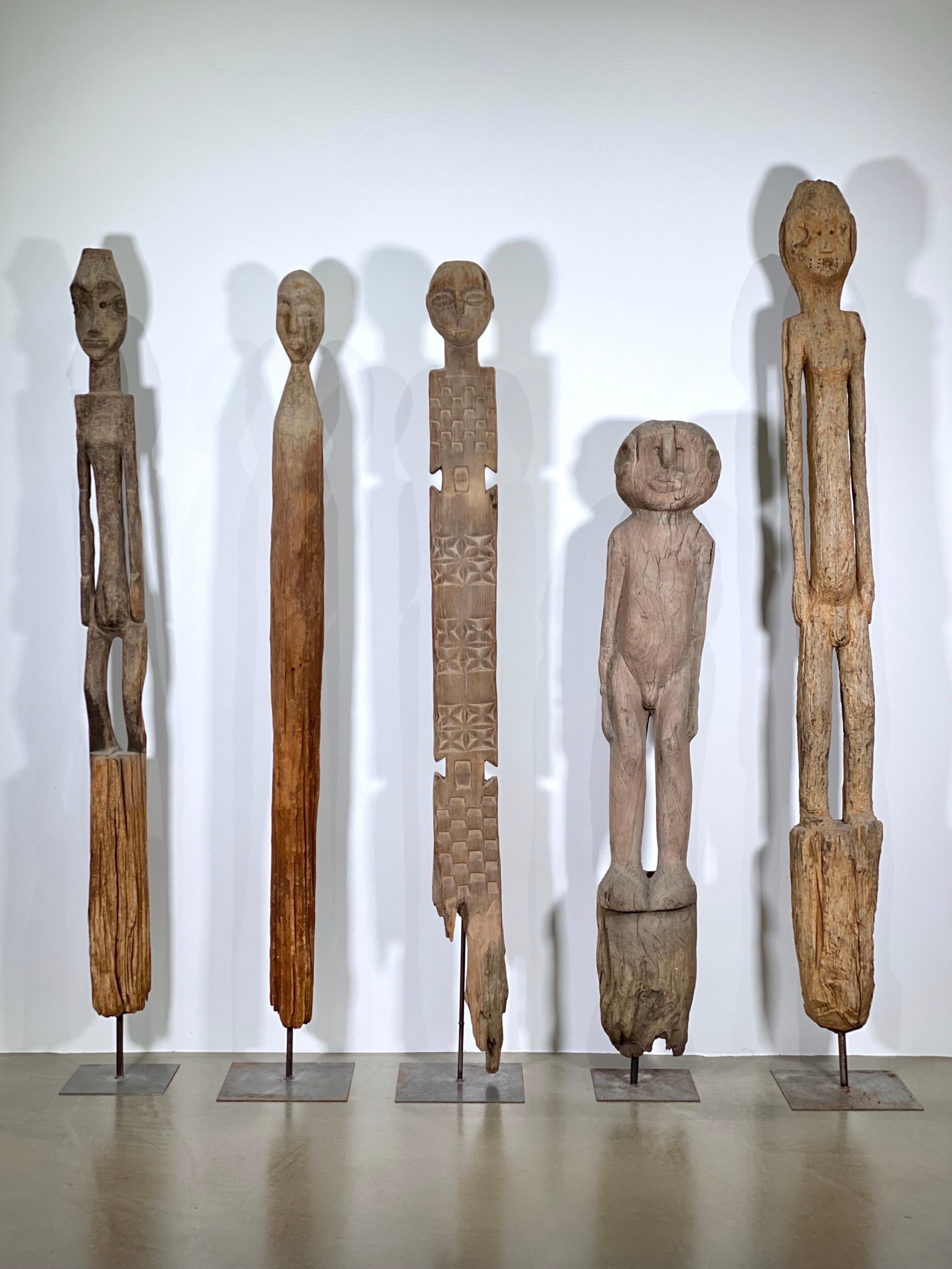 This rare ensemble consists of five monumental wooden ancestral and guardian figures, each carved from a single tree trunk and ritually planted into the earth. Two figures hail from South Sudan, while one originates from Ethiopia—likely from the