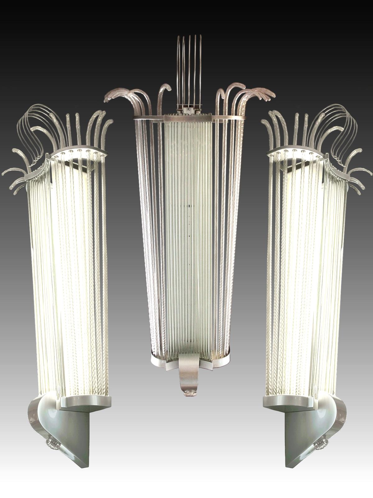 Suite of five monumental wall lamps, 1940s period.
They are made of metal, solid glass tubes and twisted blown Murano glass canes. 
The lighting consists of two large (120 cm) neon tubes for each wall lamp.

The dimensions are given in the