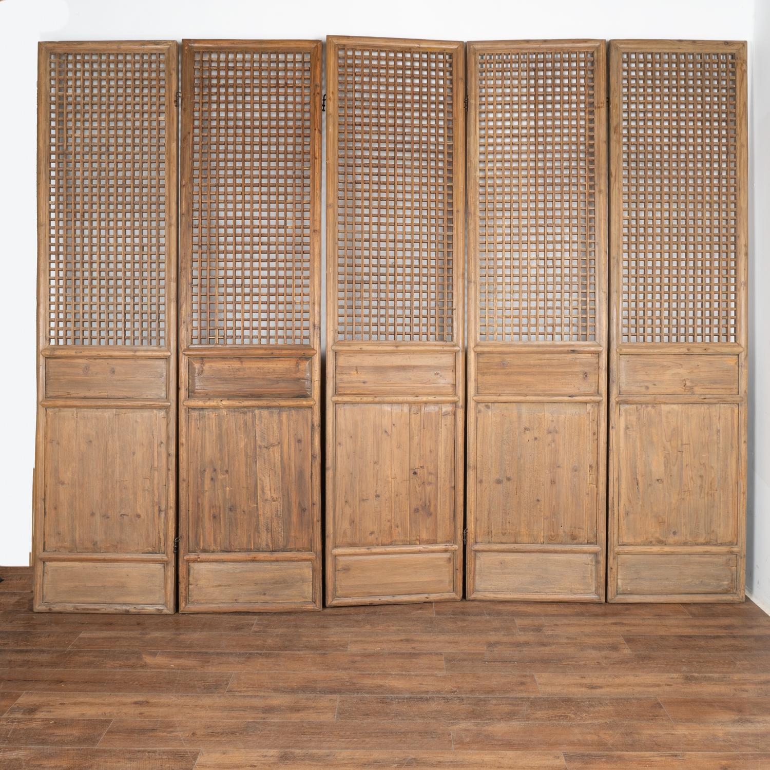 A set of five large natural elm wood interior folding screen panels with checkered fretwork that allows light to pass through the upper section.
Solid, stable vintage condition and all hinges in place. All scratches, cracks, dings, or age related