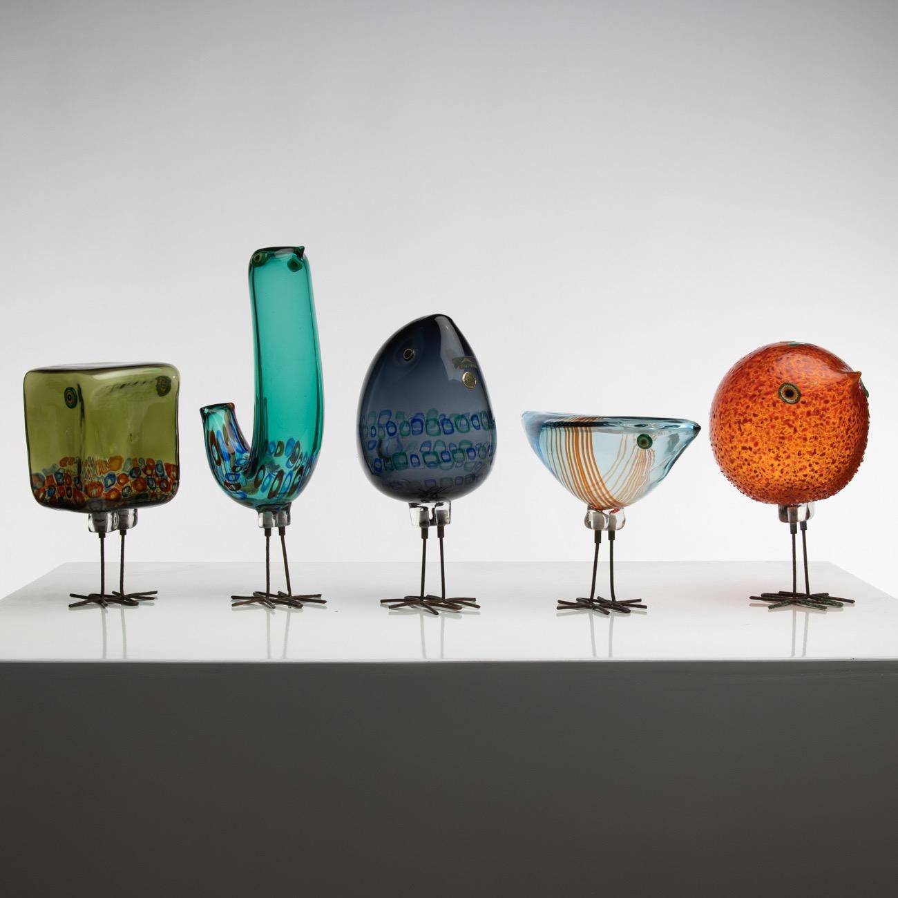 Rare set of five birds in blown glass resting on their hammered copper legs.
These are the models designed by Alessandro Pianon for Vistosi in Murano in 1962.

The first bird (left) has a cubic shape. Its body has an olive-green color with blue