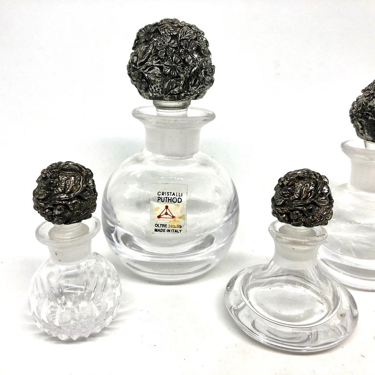 Beautiful 20th century Italian collection of five perfume bottles, all with a nice silver plated flower pattern stopper. Nice addition to your vanity room or just for your collection of perfume bottle miniatures. Found at an estate sale in