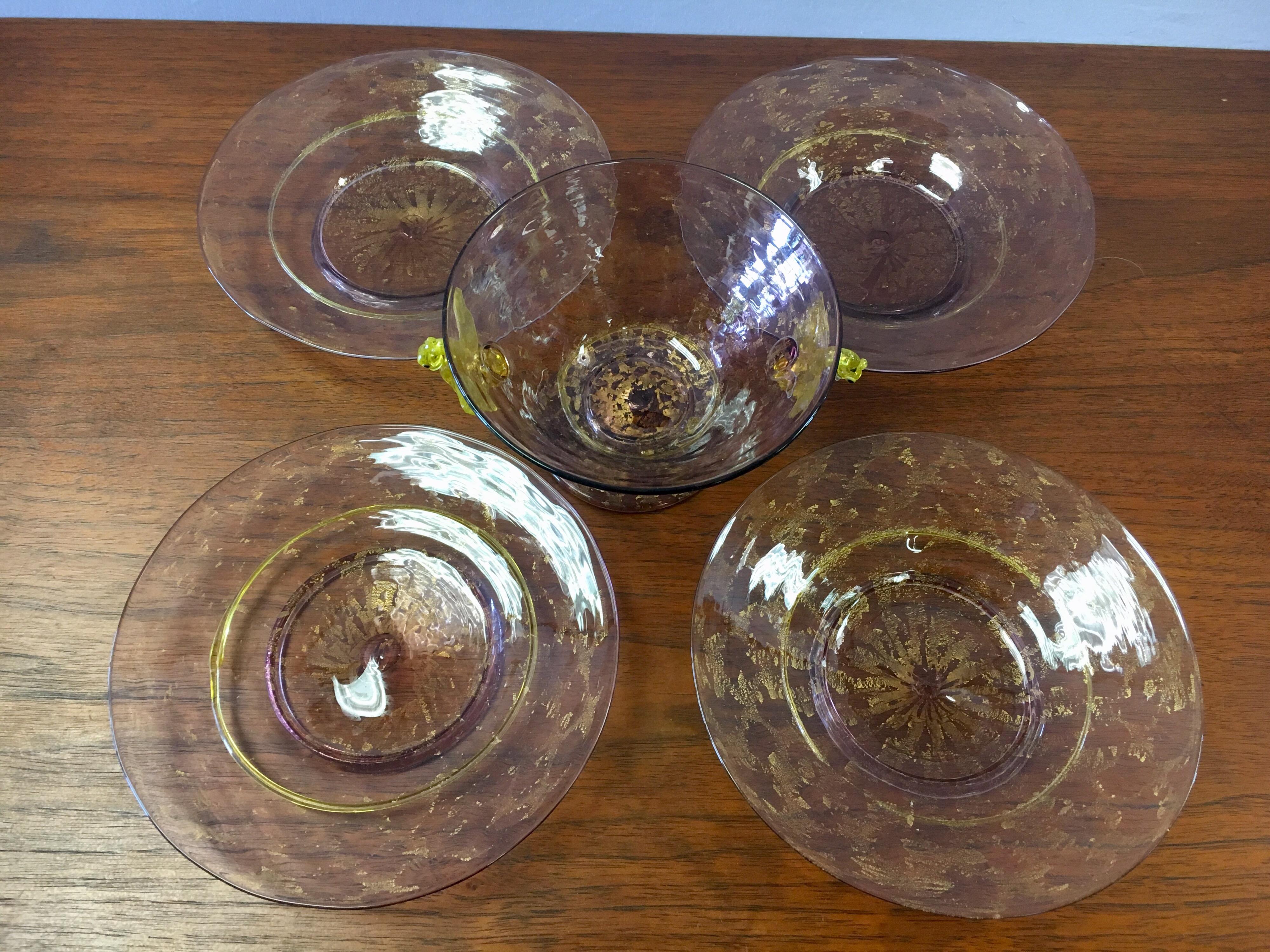 Elegant set of five Salviati hand blown glass pieces where the bowl features yellow swan connector.
The color is soft purple or amethyst with gold leaf and works well with a pastel palette. The set is for four saucers and one bowl. The saucers have