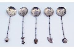 Set of five silver teaspoons with handle appliqués and cut-out shells