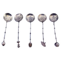 Set of five silver teaspoons with handle appliqués and cut-out shells