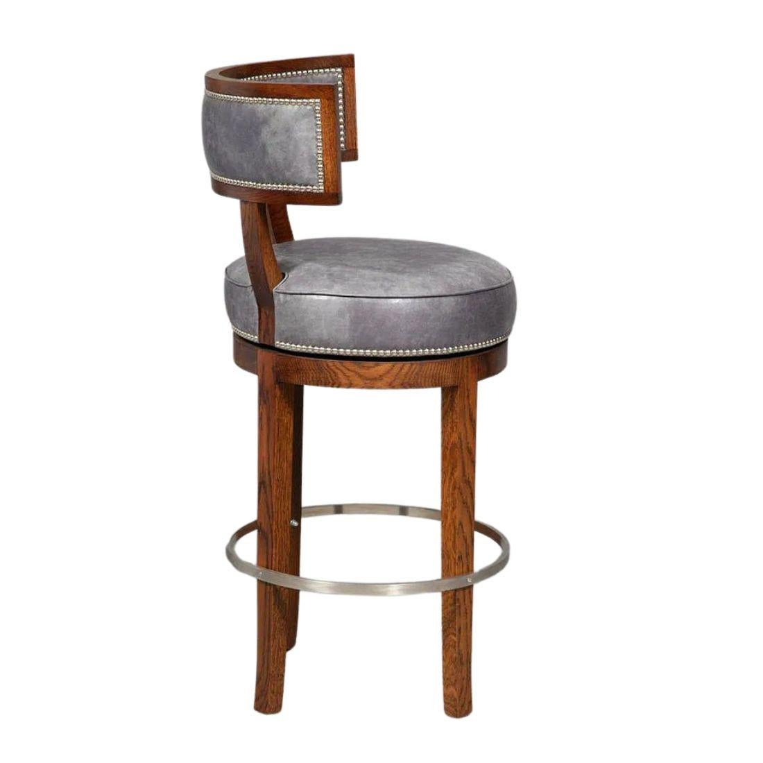 A set of five Soane bar stools in blue leather with nail head trim, curved back and metal ring stretcher . Seats swivel. Crafted by expert chair makers interpreting a classic Klismos chair