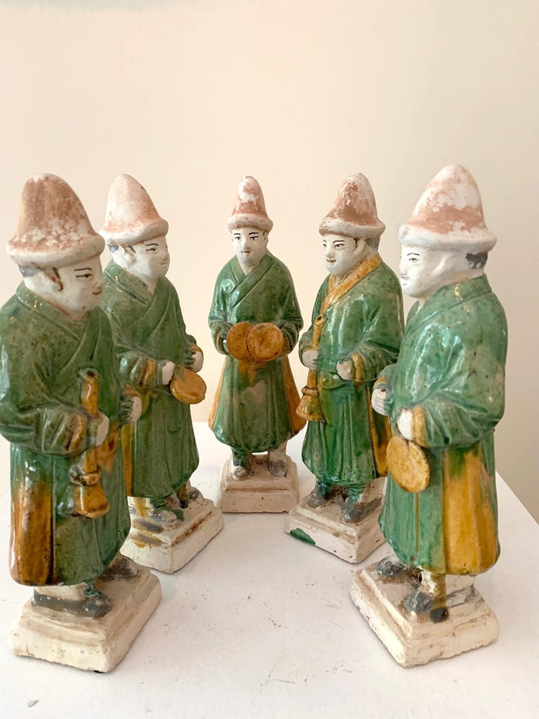 A group of five figurines made of terracotta and glazed in green and splash of yellow. These figurines of musicians were made as burial objects to be placed in the tomb, often as a larger group forming a procession for the deceased, circa Ming