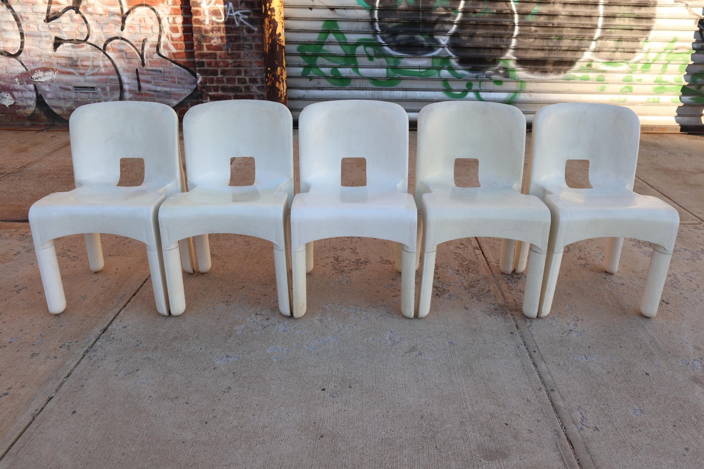 Set of five plastic chairs designed by Joe Colombo for Kartell. Chairs embossed with manufacturer and designer names. Chairs stack and are easy to clean. Great for indoor or outdoor use. All structurally sound with normal wear for age. No structural