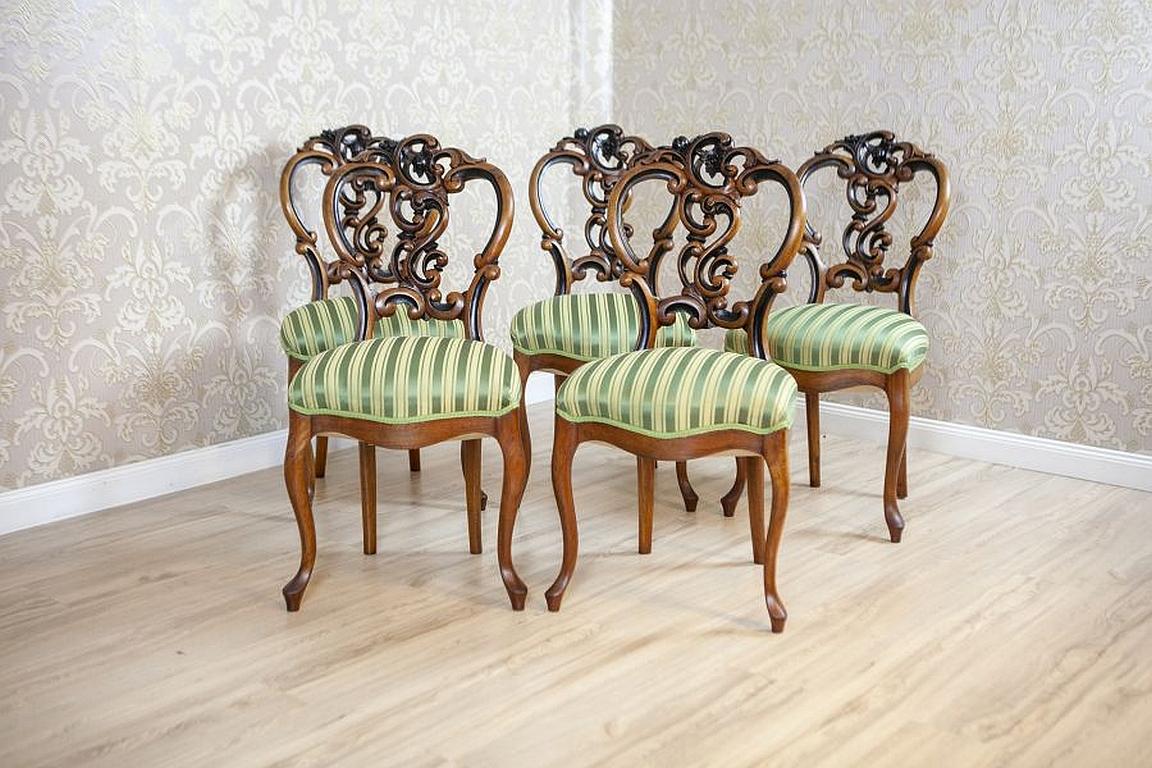 Set of Five Walnut Chairs From the Late 19th Century in Light Green Upholstery

We present you five walnut chairs from the late 19th century. The furniture is placed on bent legs, which are finished with volute feet. The backrests are covered with