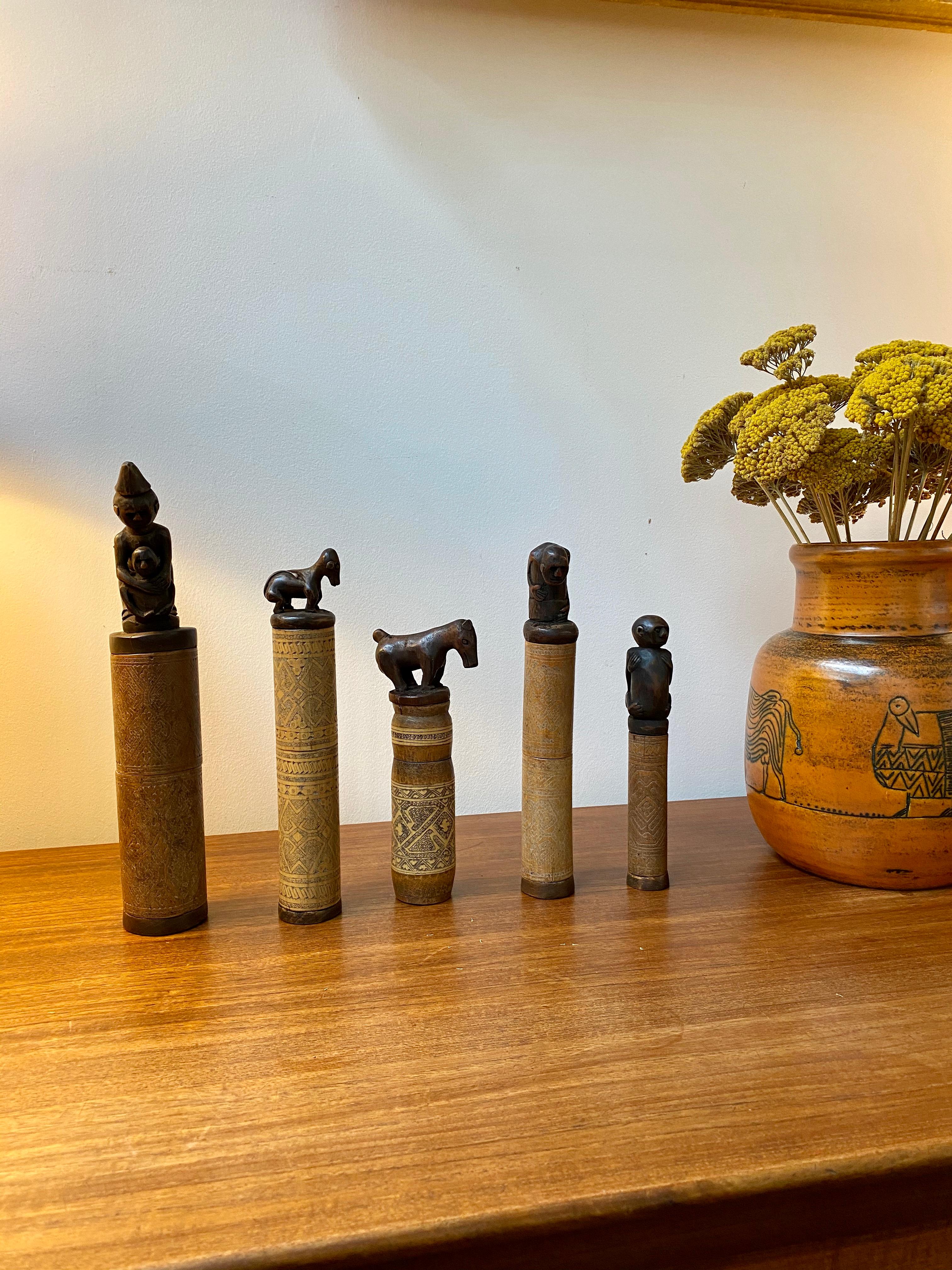 Set of five wood and bamboo lime powder holders for betel nut from West Timor Island, Indonesia (circa 1940s-1960s). These beautiful receptacles are made of bamboo with incised traditional decoration and beautifully carved wooden stoppers in the