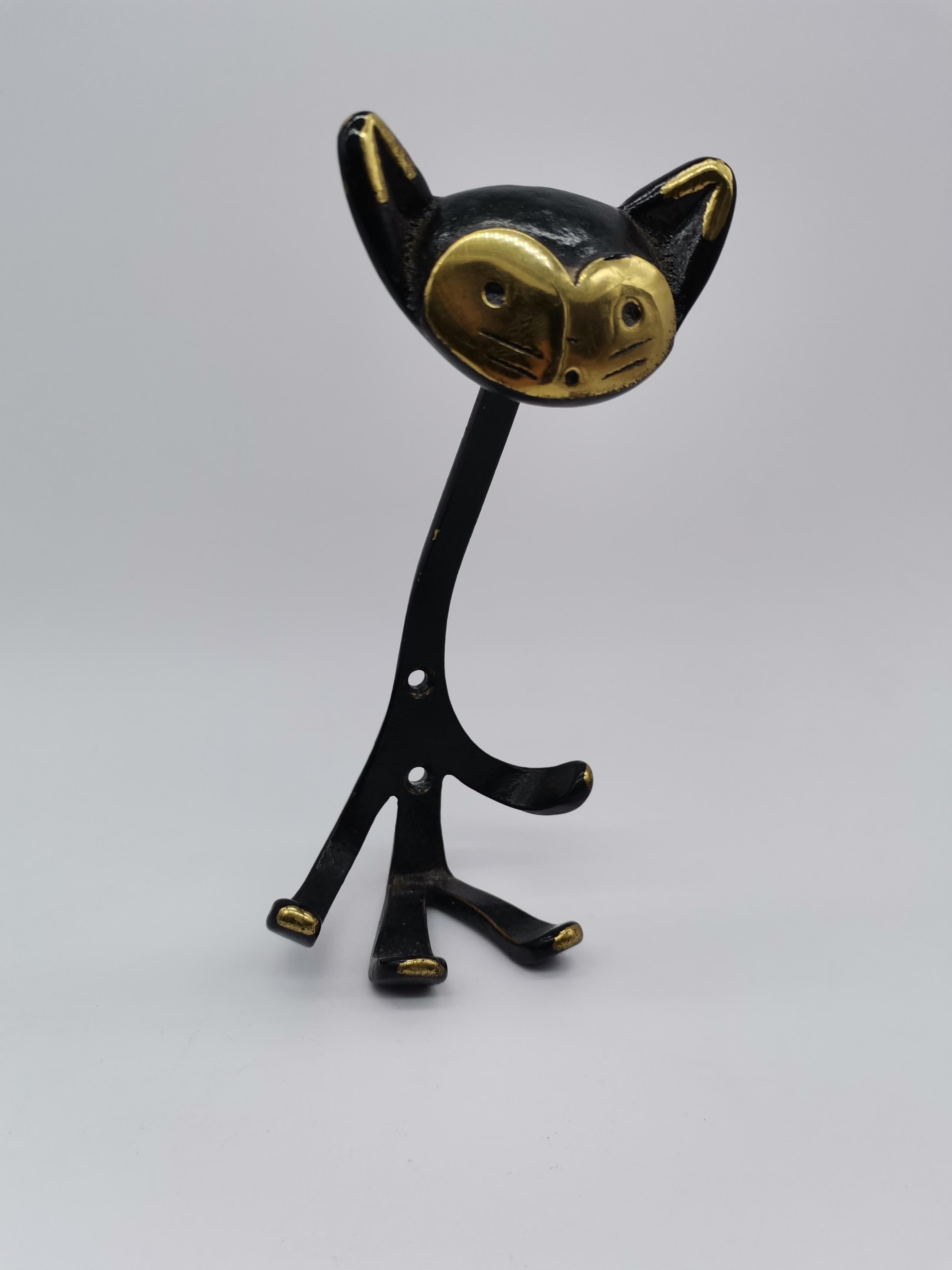 A set of 5 coat racks designed by Walter Bosse in cat shape. Brass partially blackened.