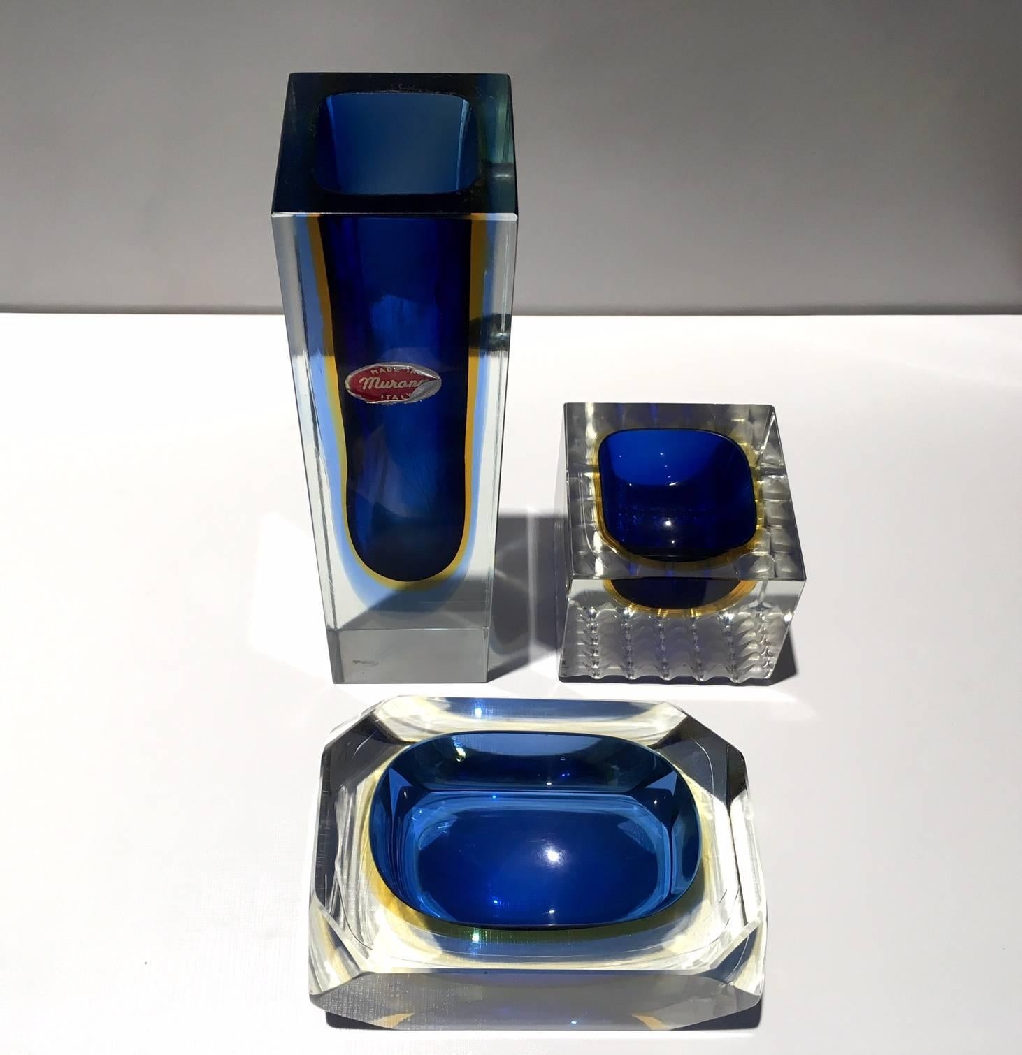 Set of three Italian Murano glass pieces attributed to Flavio Poli. Set of vase, small ashtray and a small dish. Faceted sides and a gorgeous color combination of blue and yellow. These pieces shine beautifully as they capture and reflect the