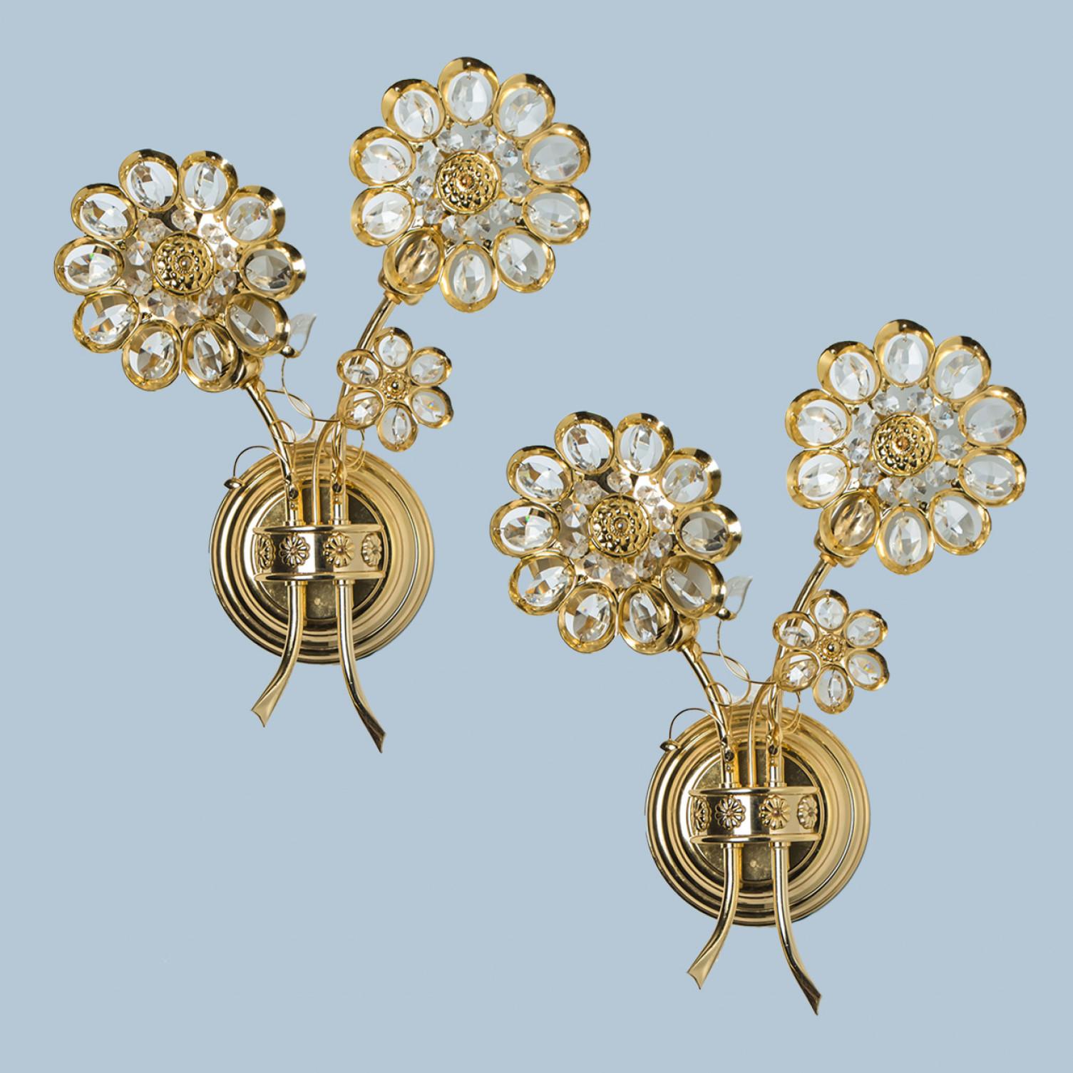 A stunning set of gilt and crystal wall-mounted sconce by Palwa, Germany. Manufactured around 1965-1975.
This luxurious wall light features beautifully cut crystals in the form of three flowers and petals set on a gold-plated brass