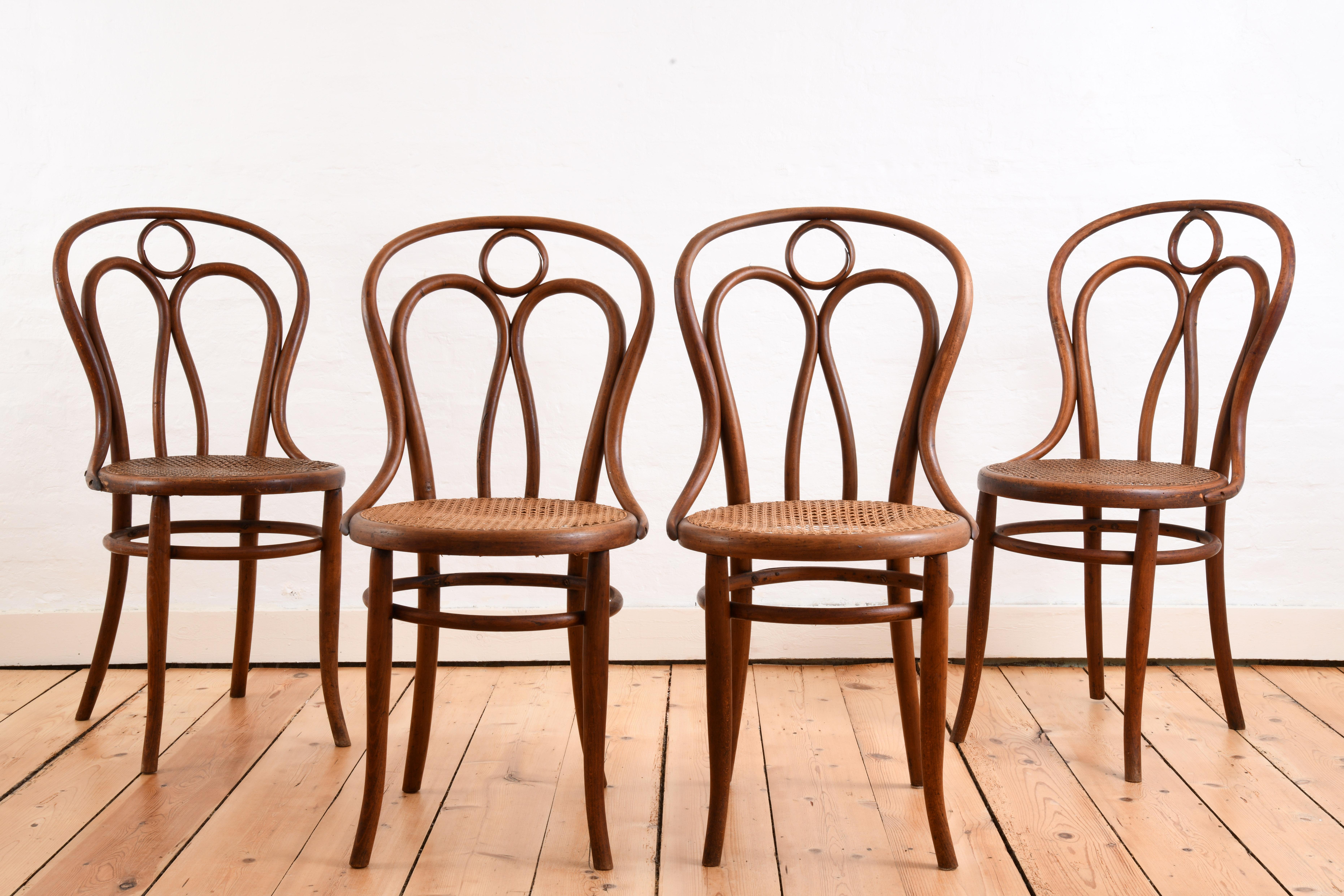Ensemble de quatre chaises en bois courbé avec assise en rotin, produites par J&J Kohn en Autriche au début du 20e siècle. Il s'agit du modèle numéro 36, comme le montrent les reproductions du catalogue de 1904. Les chaises sont en bon état pour