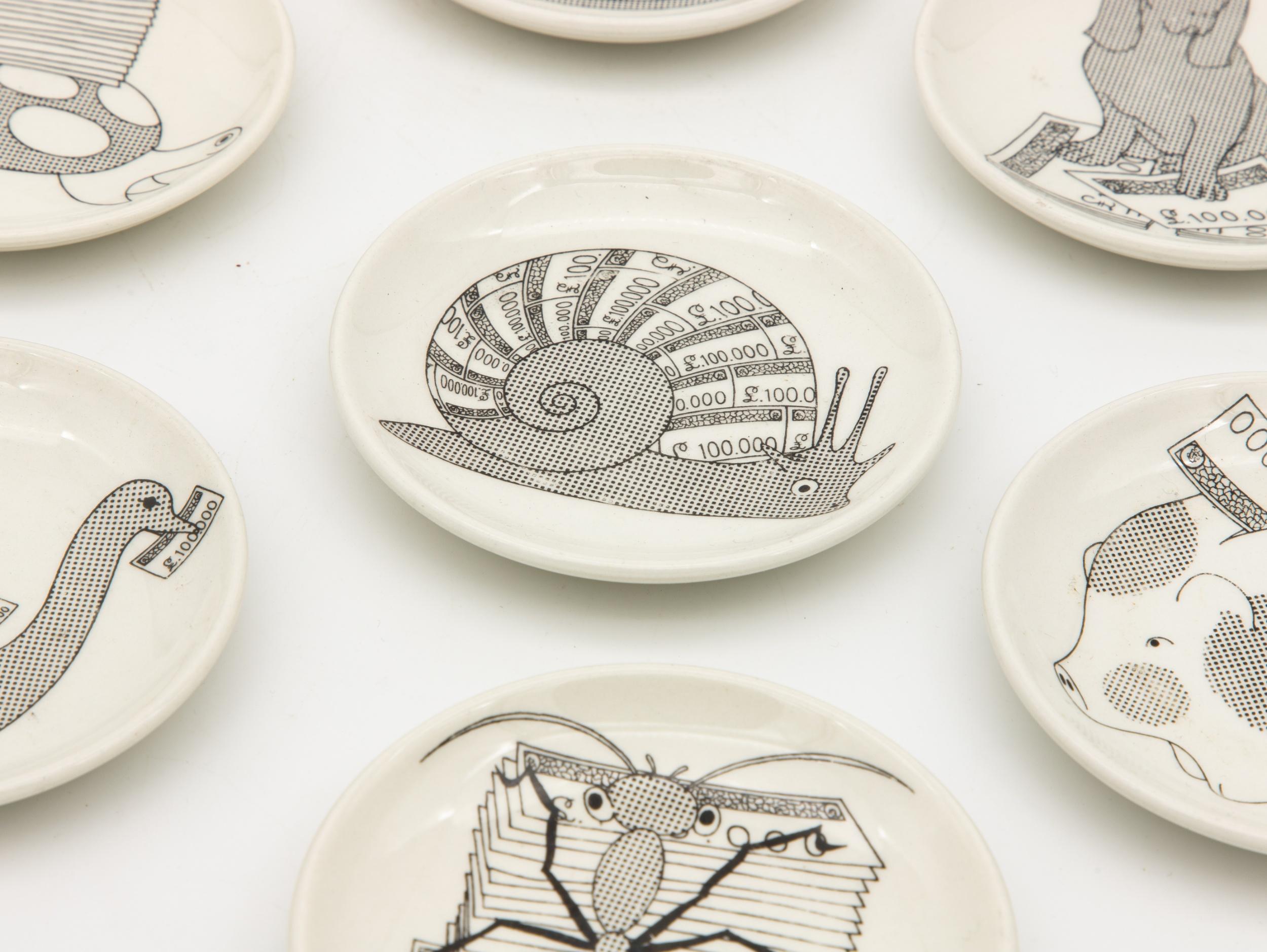 Set di sette sottobicchieri Fornasetti in bianco e nero con lumaca, salvadanaio, cane, gallina, tartaruga, anatra e formica.