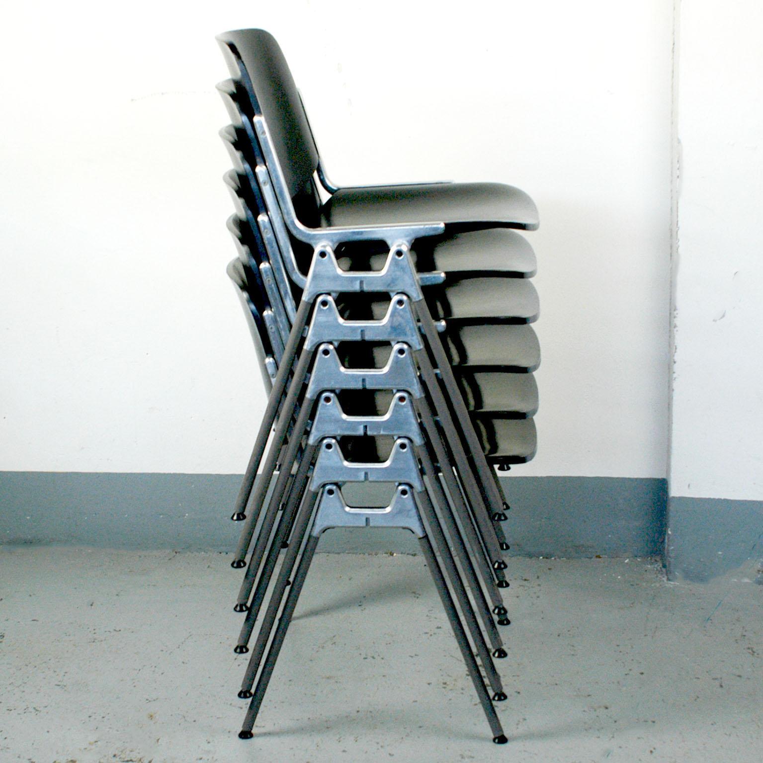 Set of four iconic Italian Modern DSC 106 stacking chairs, designed 1965 by Giancarlo Piretti for Castelli. This set features black lacquered seats and backs, they are in very nice condition with a few signs of wear due to their age. Perfect and