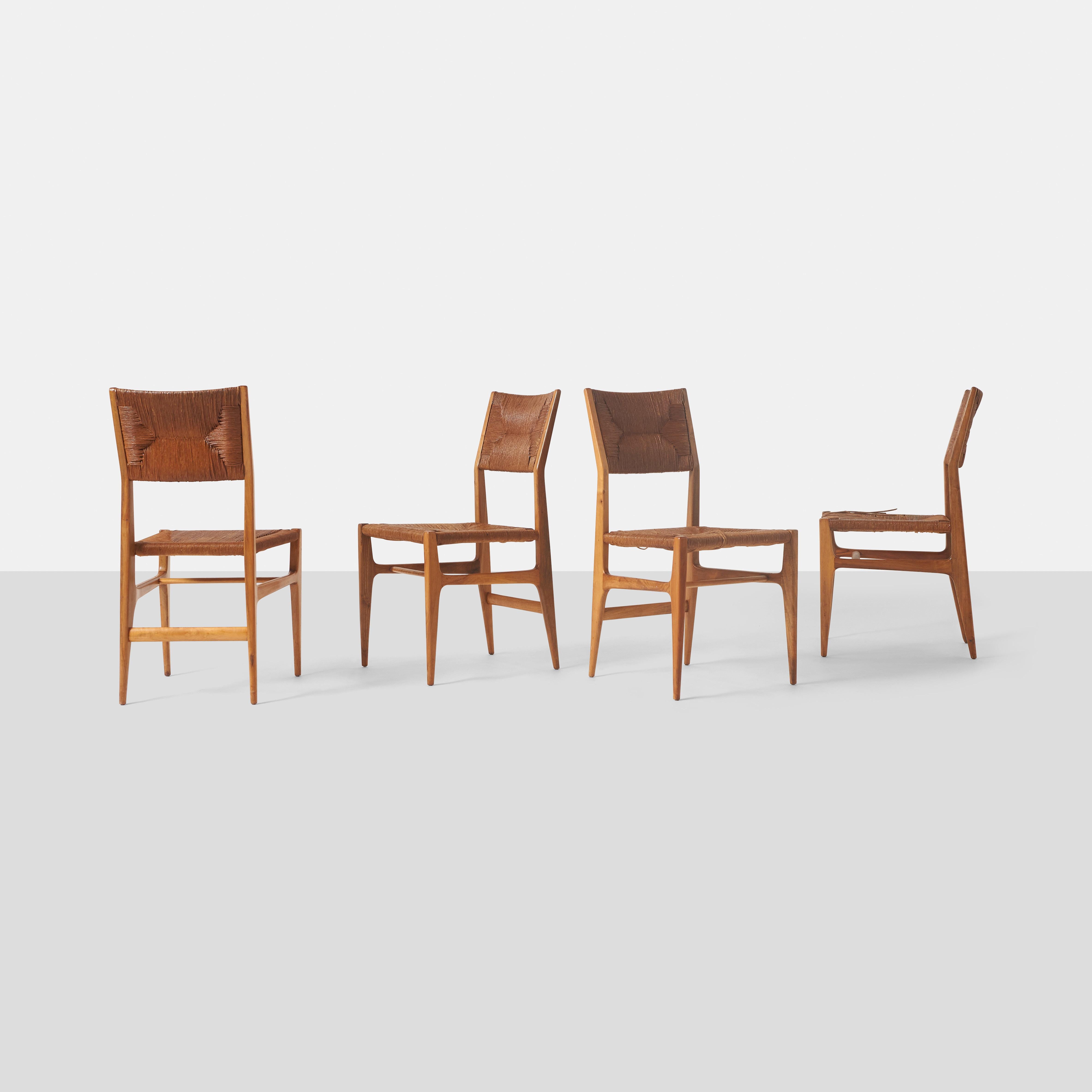 A set of #116 Dining Chairs in walnut, with original rush seats by Gio Ponti for M Singer & Sons of New York.