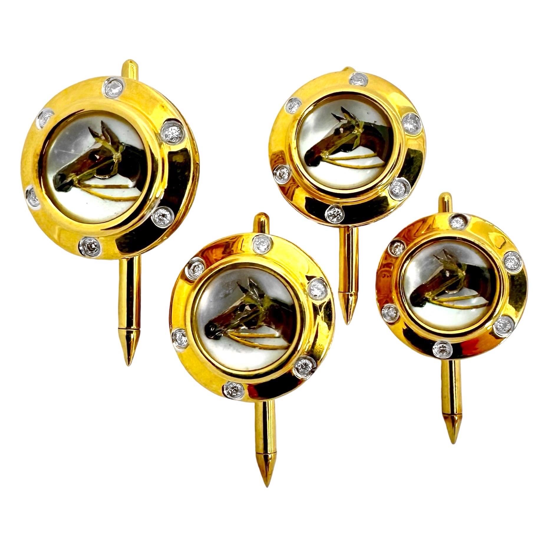 Estos bonitos botones ecuestres pintados al revés son ideales para el caballero que ama a los caballos. El juego de cuatro botones está fabricado en oro amarillo de 18 quilates y presenta cabezas de caballo pintadas a mano sobre fondos de nácar.