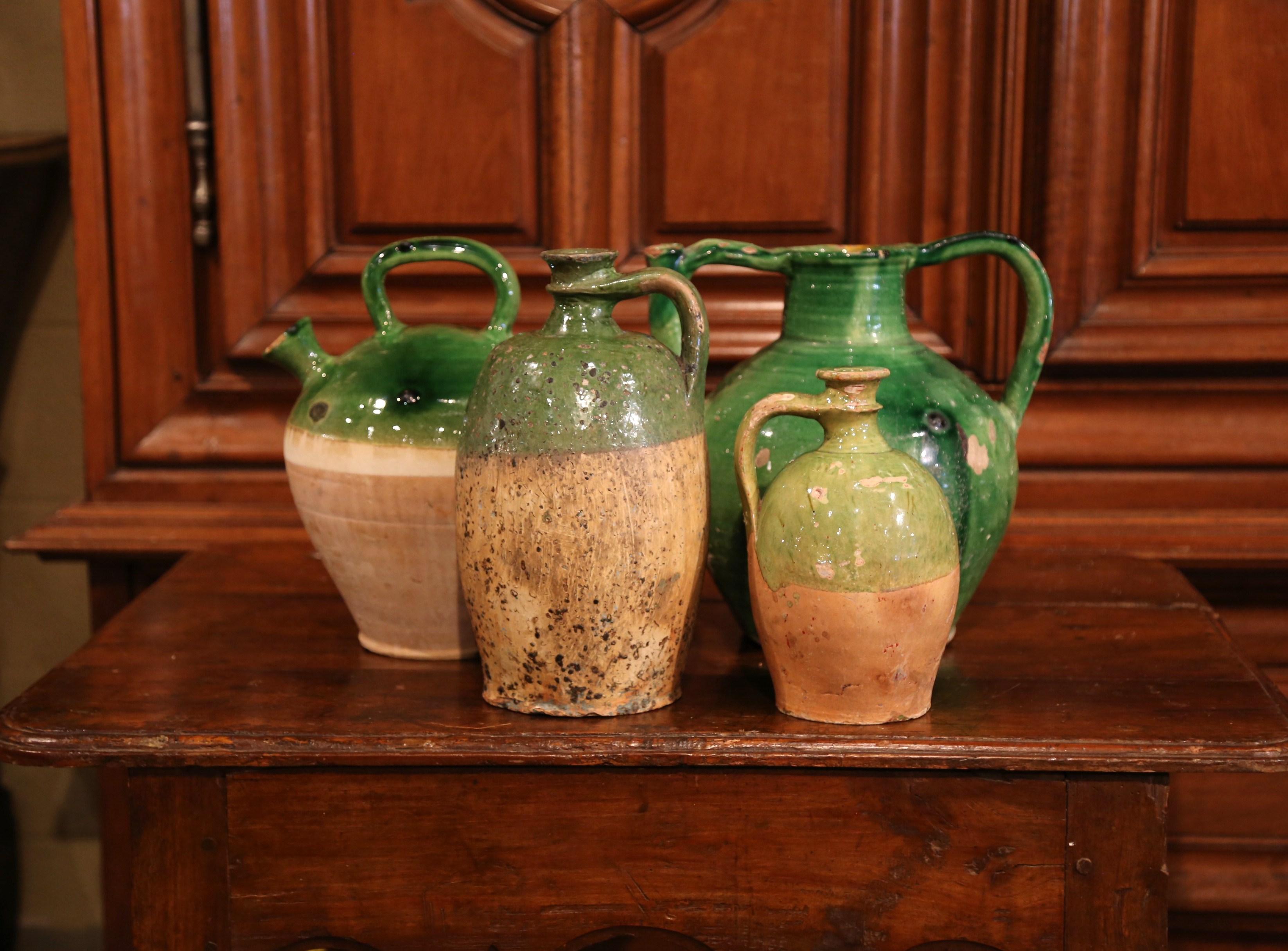 Add color to your kitchen with this set of antique olive pitchers from Southern France crafted, circa 1790, each handcrafted bottle features a handle for pouring and is embellished by a two-tone finish; green glazed and terracotta. The colorful jars