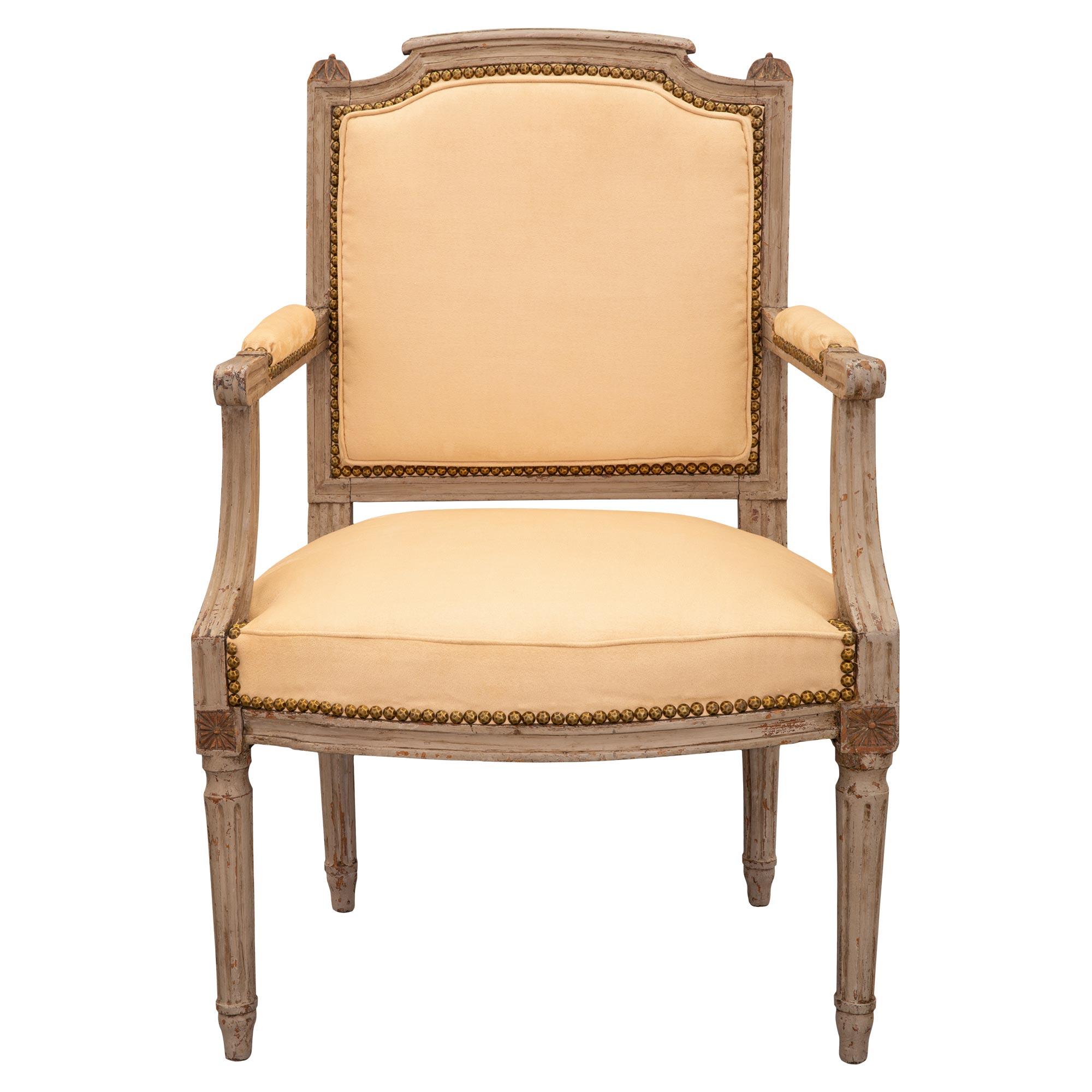 Encantador juego de cuatro sillones franceses del siglo XVIII de época Luis XVI patinados. Cada una tiene un respaldo rectangular tapizado, la barra superior está estriada y flanqueada por hojas de laurel circulares talladas en capitel. Los