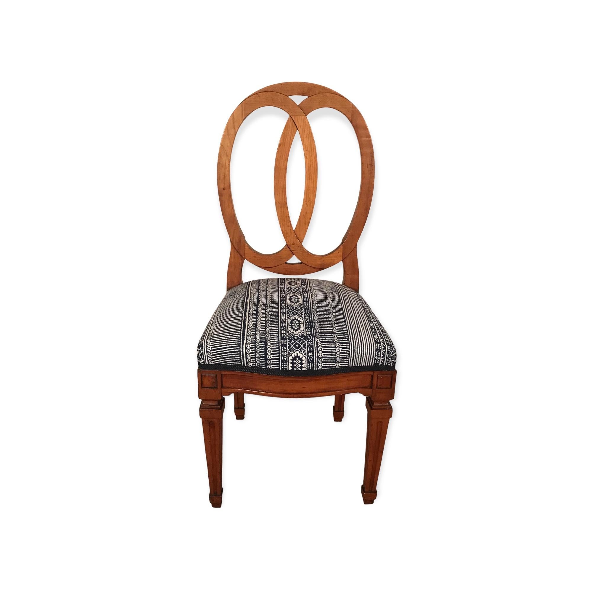 This unique set of four 18th century Louis XVI Chairs comes from Southern Germany. The chairs have a beautiful open back brezel design. They feature a pretty hand carved cherry wood which was carefully refinished without touching the original