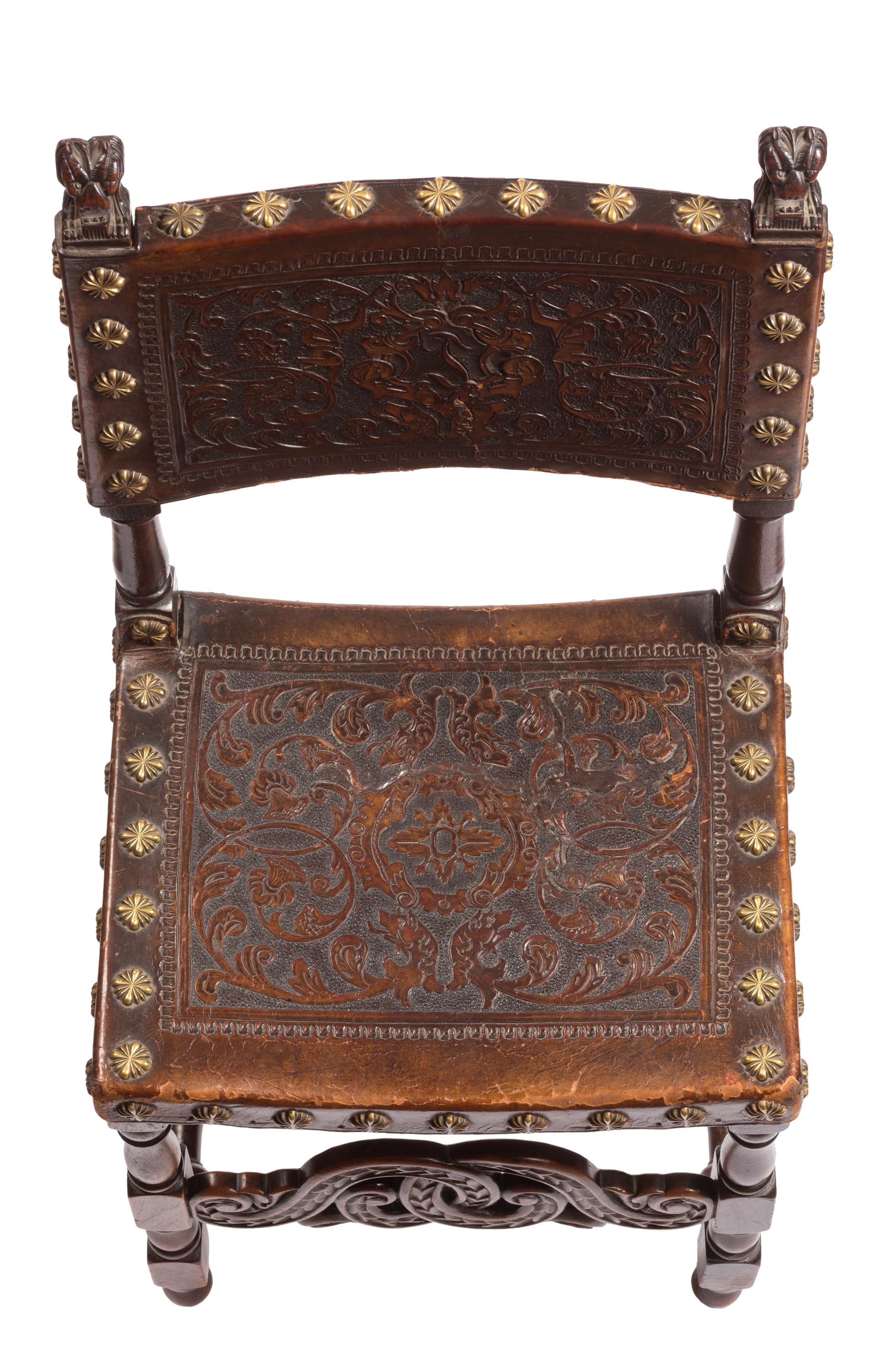 A matched set of four 18th century Spanish embossed leather chairs with nicely hand-carved detailing. The leather of the chairs are decorated with intricate flower and vine designs on the seats, and on the backs there are abstract vines surrounding