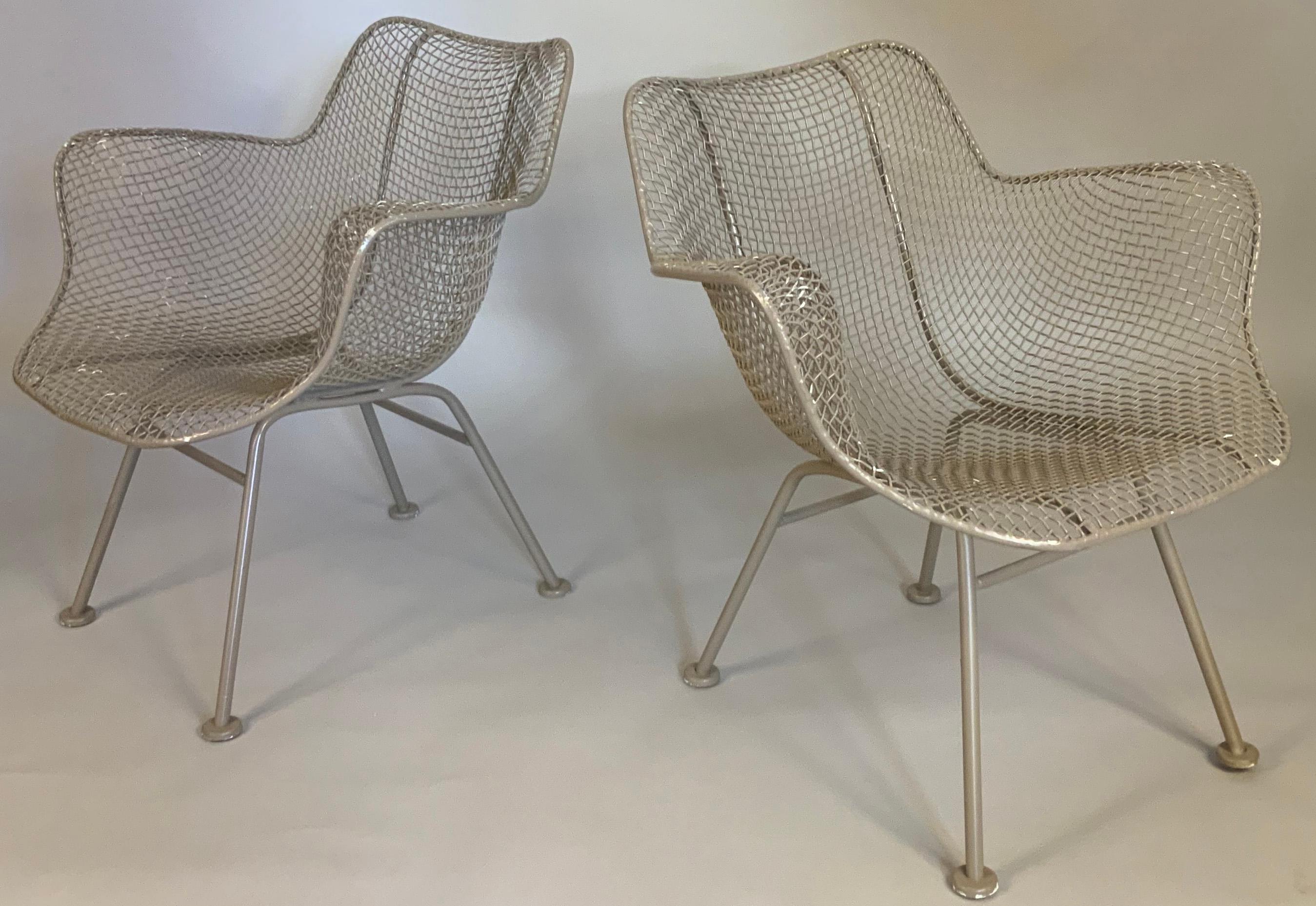 A matched set of four vintage 1950's Sculptura armchairs designed by Russell Woodard. these iconic chairs have woven steel mesh over curved wrought iron frames. they are in a beige finish, which has some losses. can be stripped and refinished in any