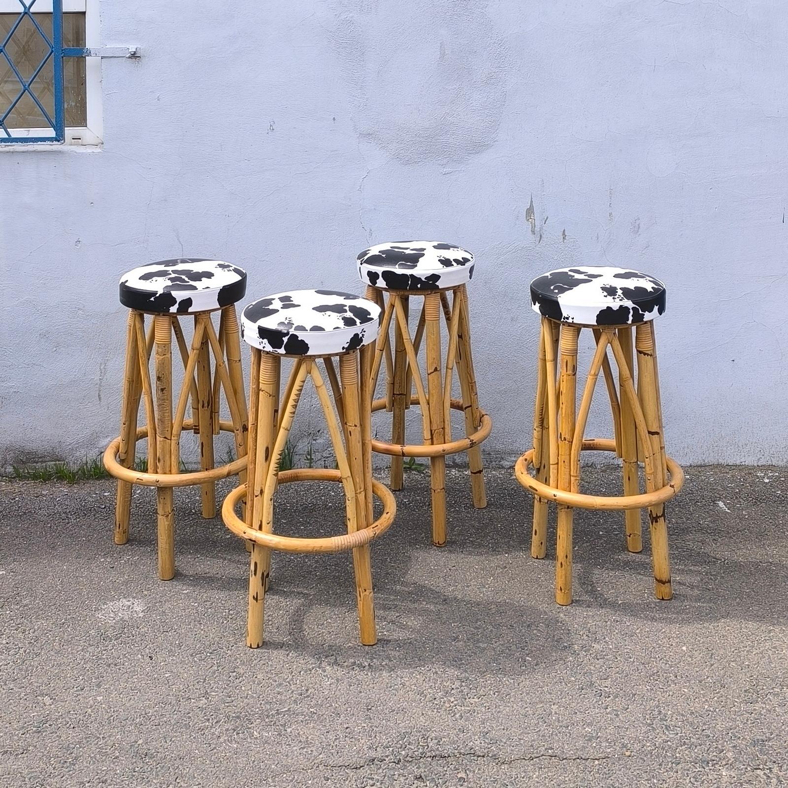 Set of four 1960s bamboo or rattan bar stools. Seats are covered in original faux cowhide leather. Good condition due to age and use. Minor wear to the legs. 
Height 85 cm, seat diameter 35 cm
The shipping price for the USA includes the crating!