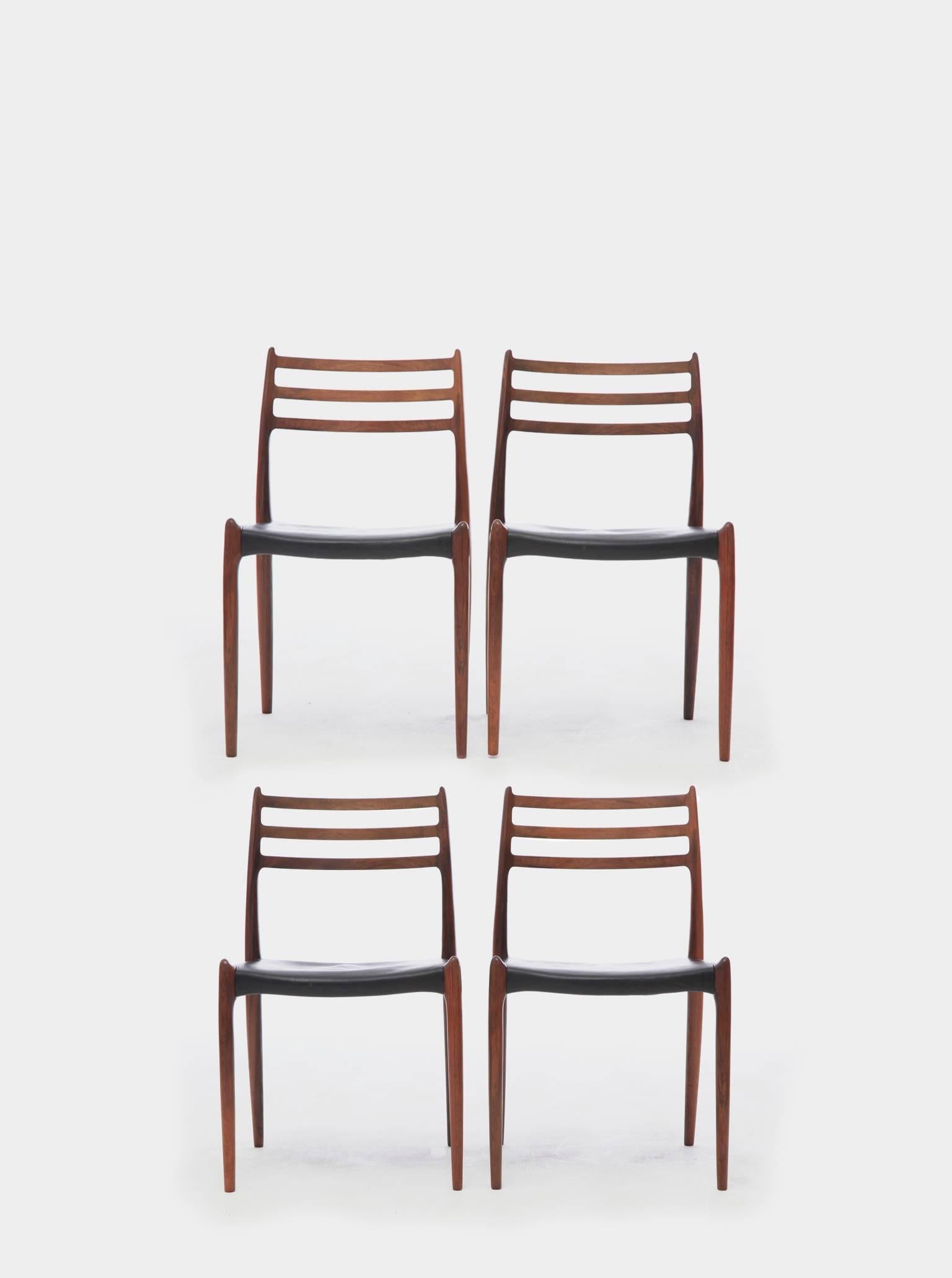 A set of four rosewood N.O. Møller 78 side chairs, 1962 for J.L. Møllers Møbelfabrik, Denmark. Rosewood, leather seat covers.

  