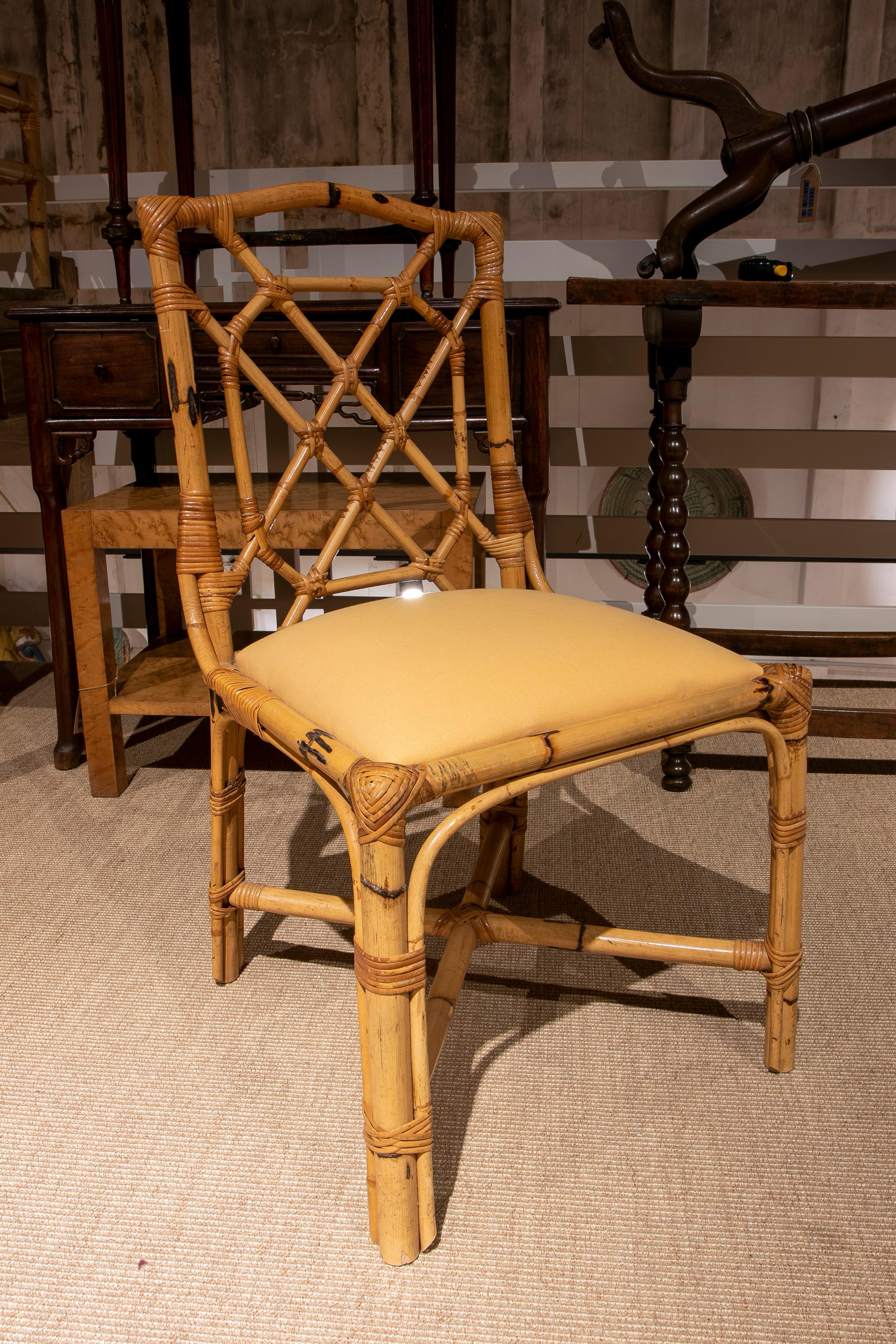 Ensemble de quatre chaises anglaises vintage des années 1970 en bambou avec sièges tapissés de tissu crème.